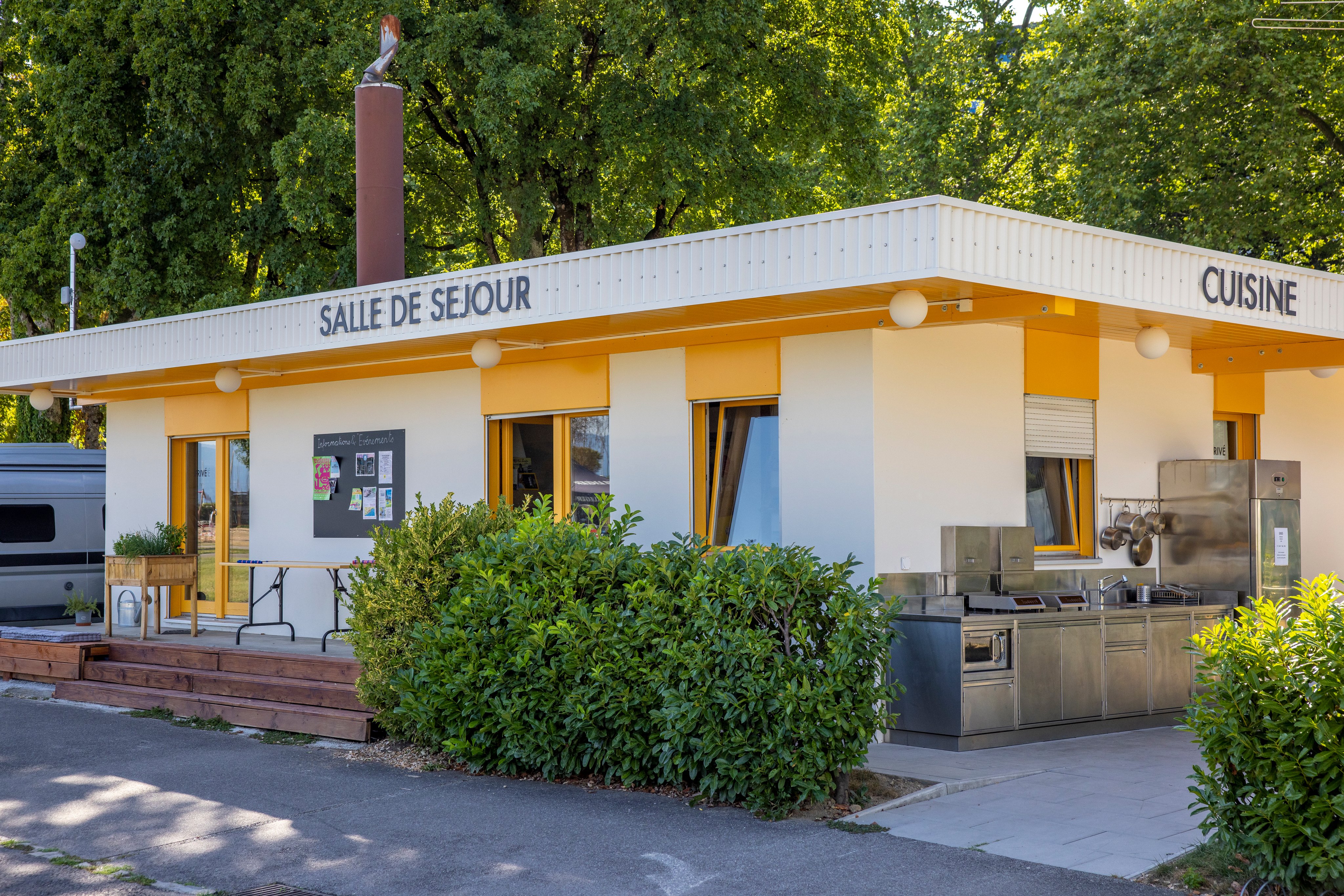 A building with a lounge and an outdoor kitchen on a campsite.