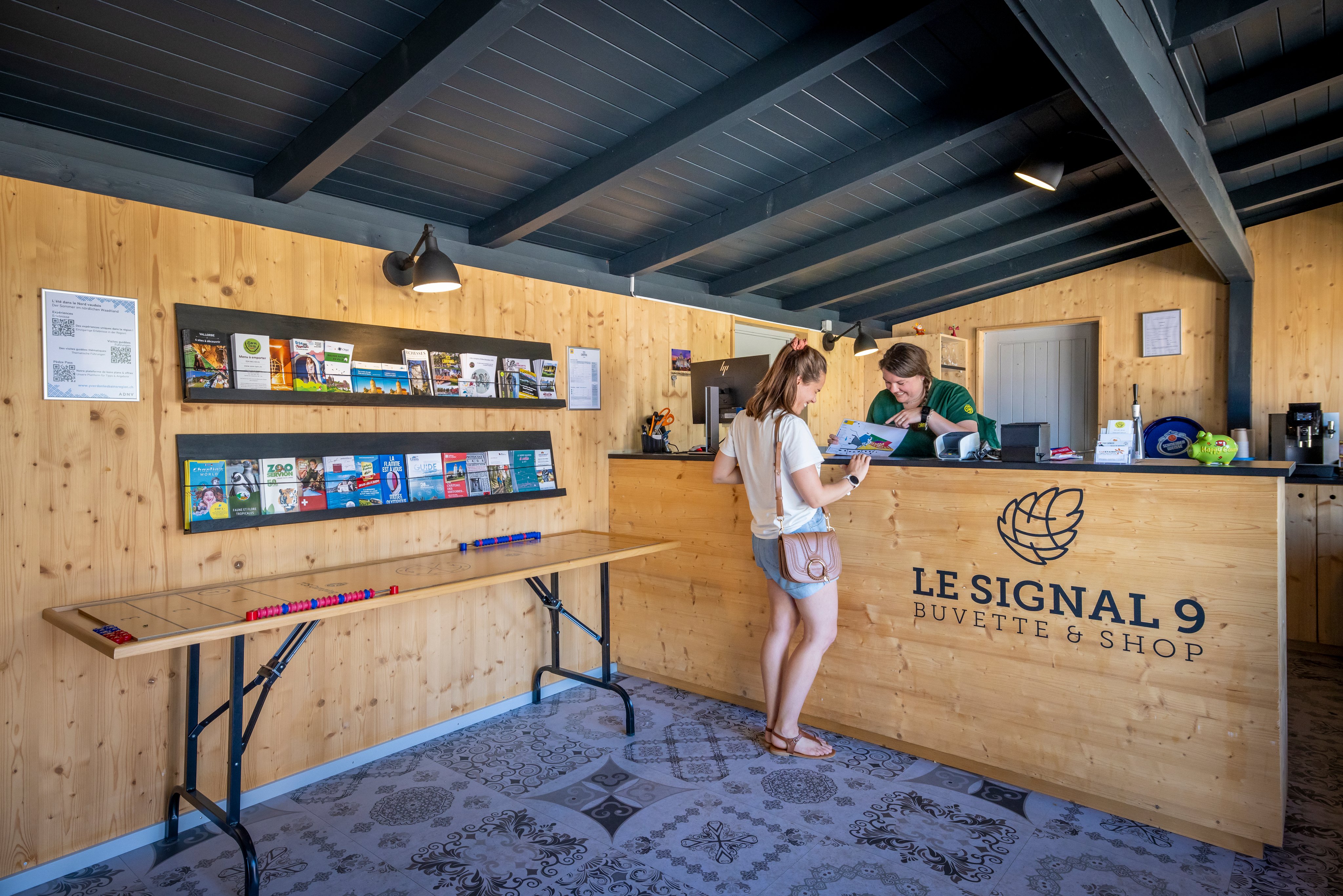 Two women at a reception desk looking at a plan.