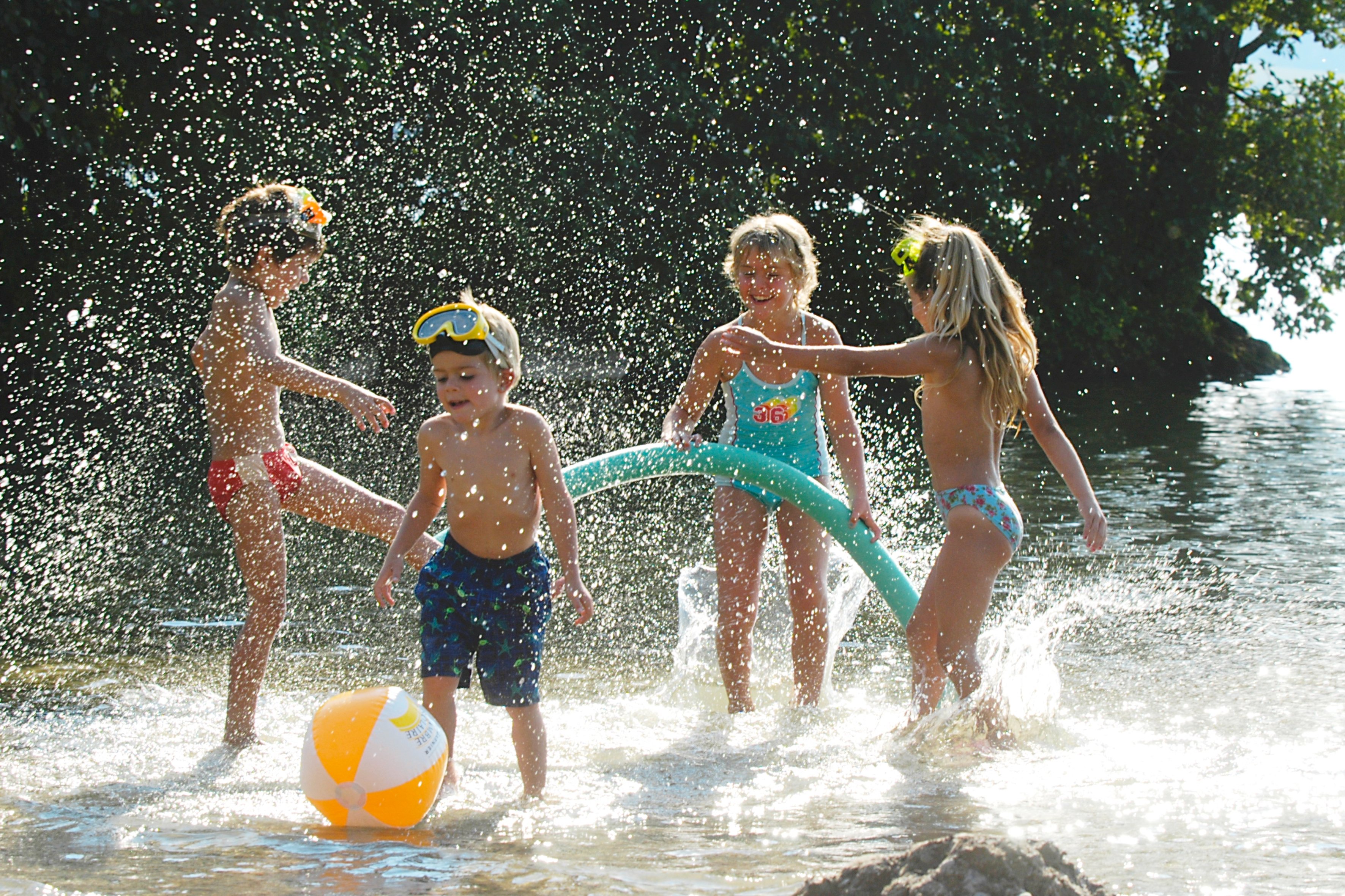 Quatre enfants jouant dans l'eau.