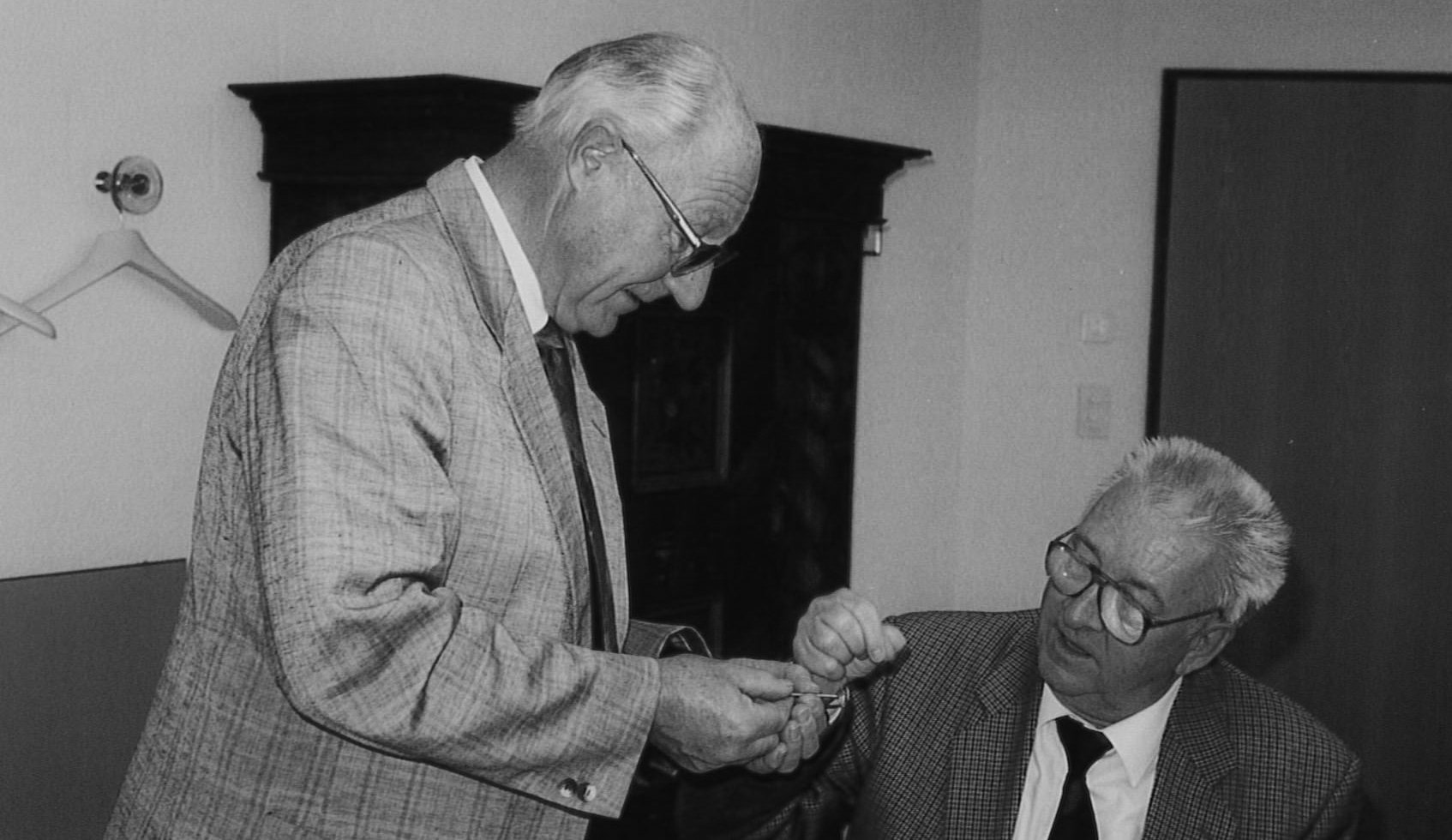 Historic black and white photograph of Heinz Oertli and Albert Klöti discussing early vitrectomy instrumentation.