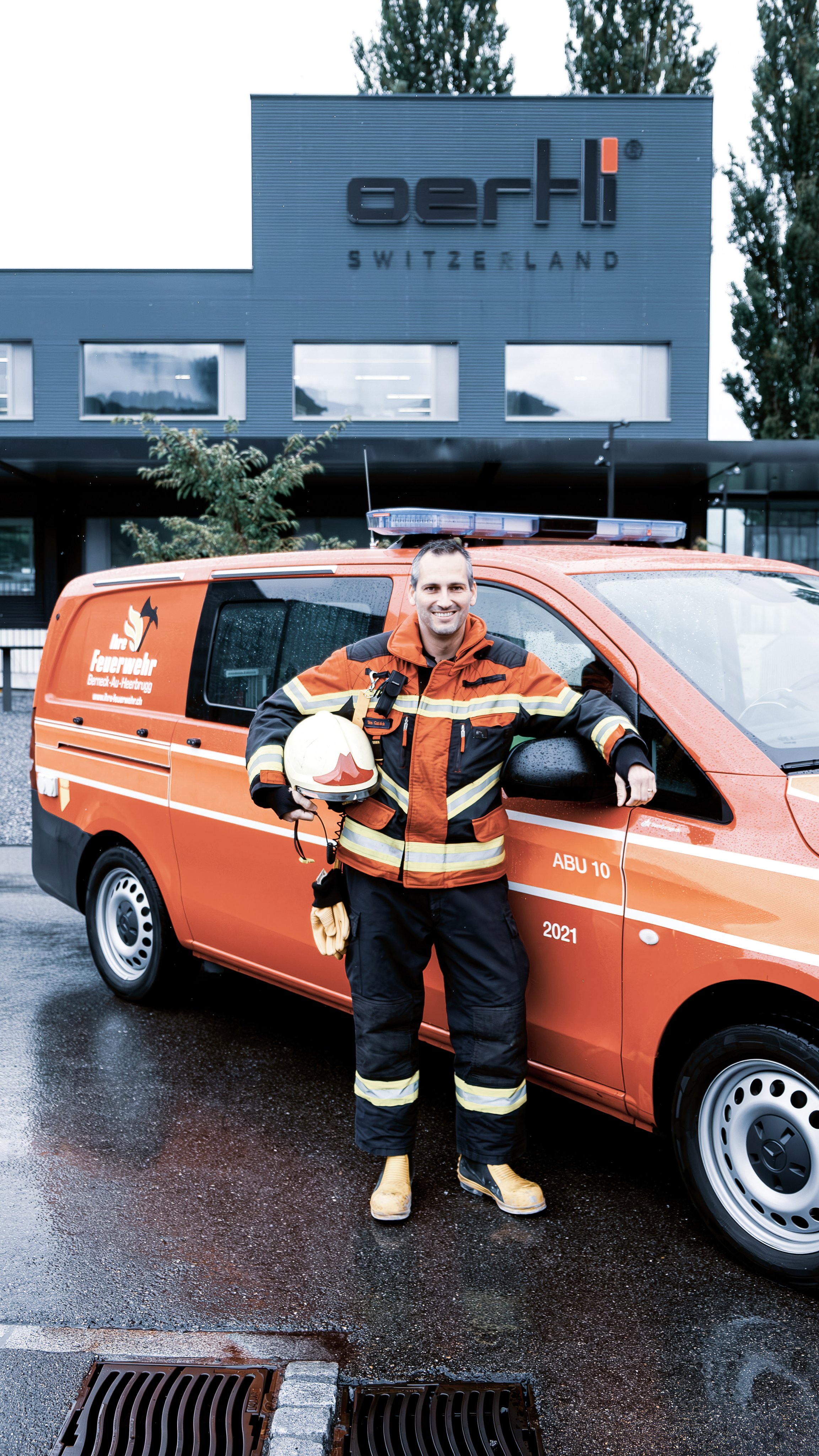 Feuerwehrmann Silvio Gablick posiert vor dem Oertli Gebäude mit dem Einsatzfahrzeug