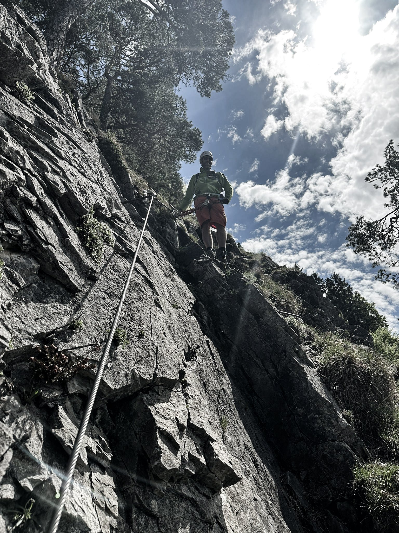 Freizeitaktivität vom Mitarbeiter in den Bergen mit Kletterausrüstung und sonnigem Himmel