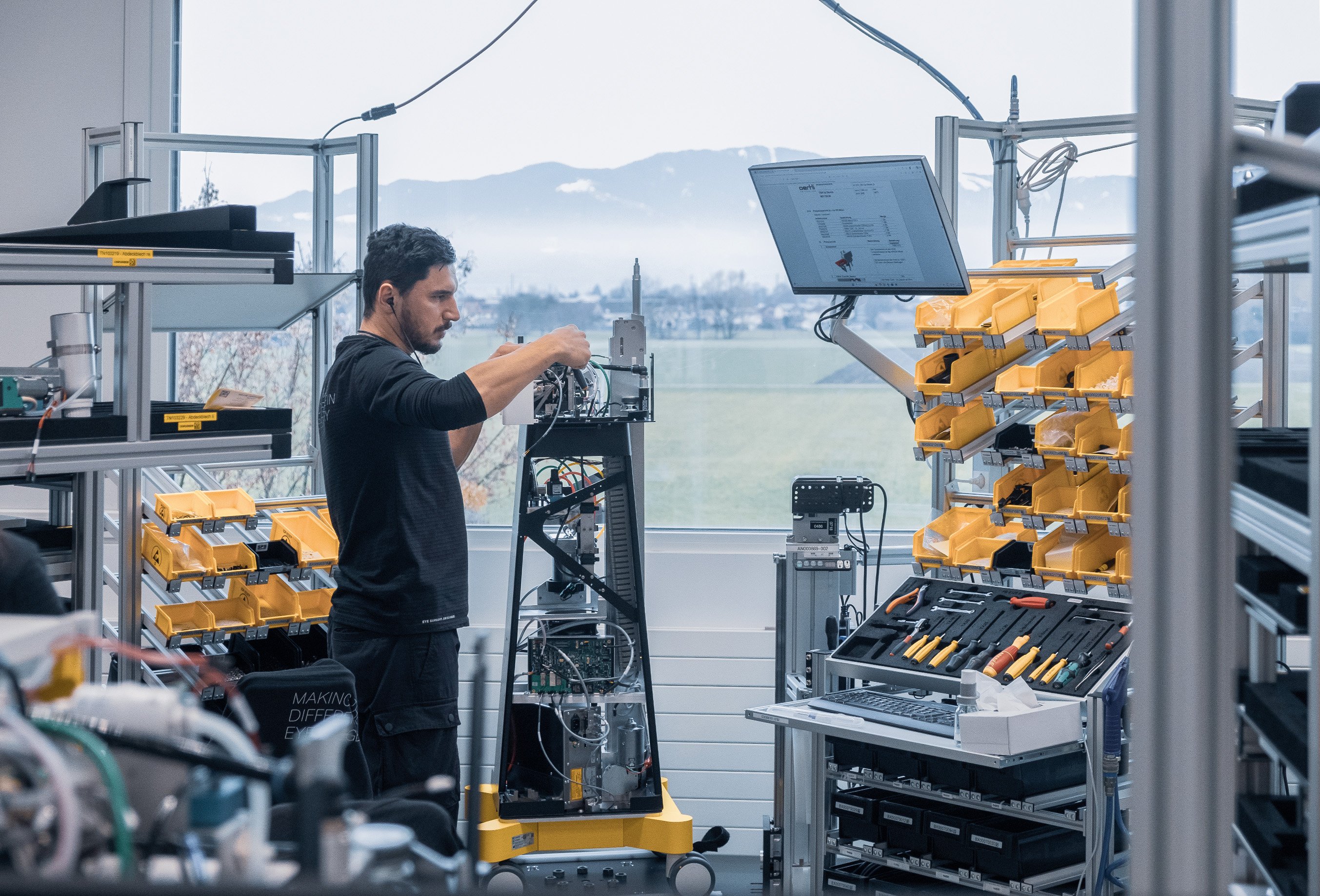 Employee assembling and testing an ophthalmic surgical system in a technical production environment