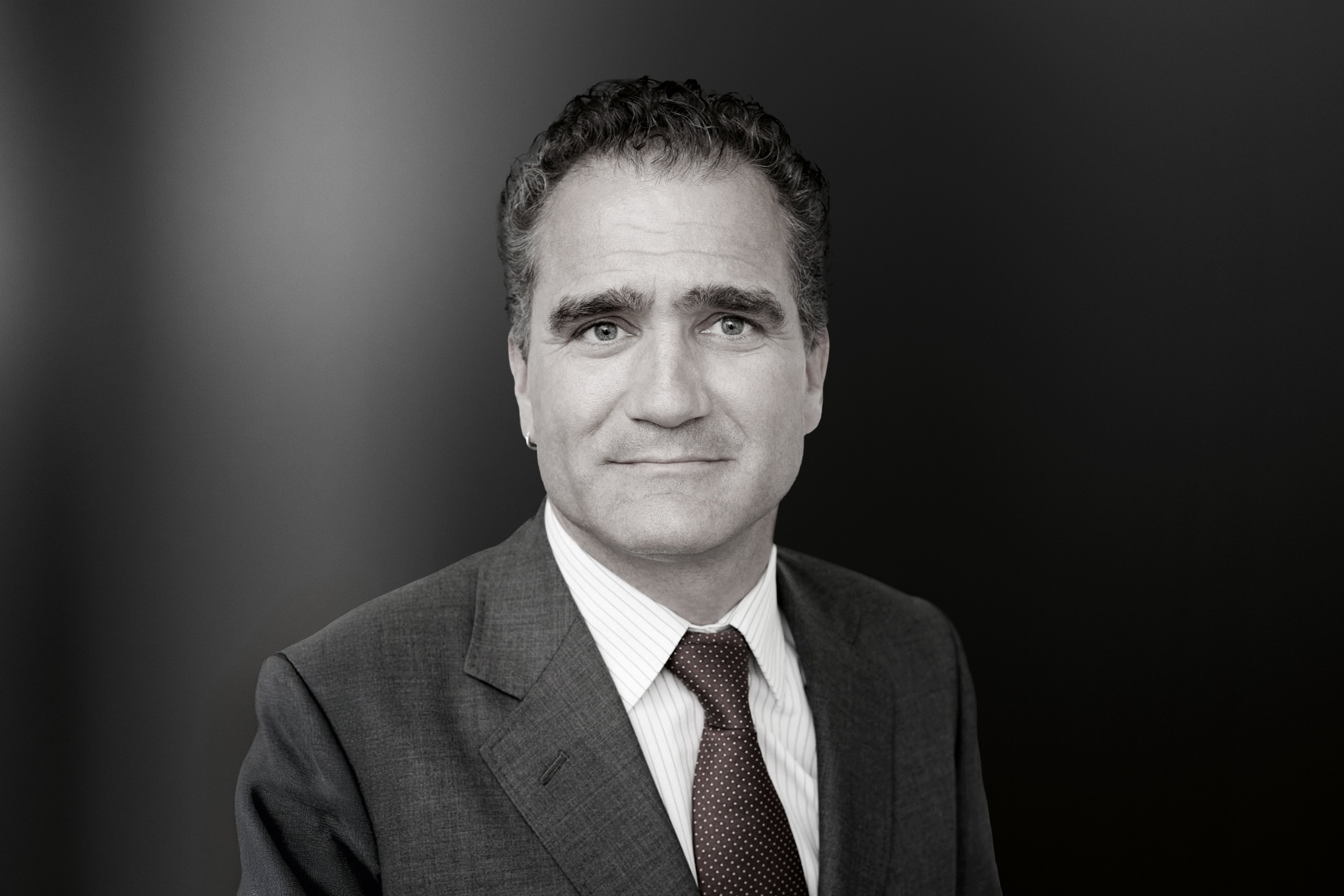 Portrait of a male ophthalmologist in a suit against a neutral background