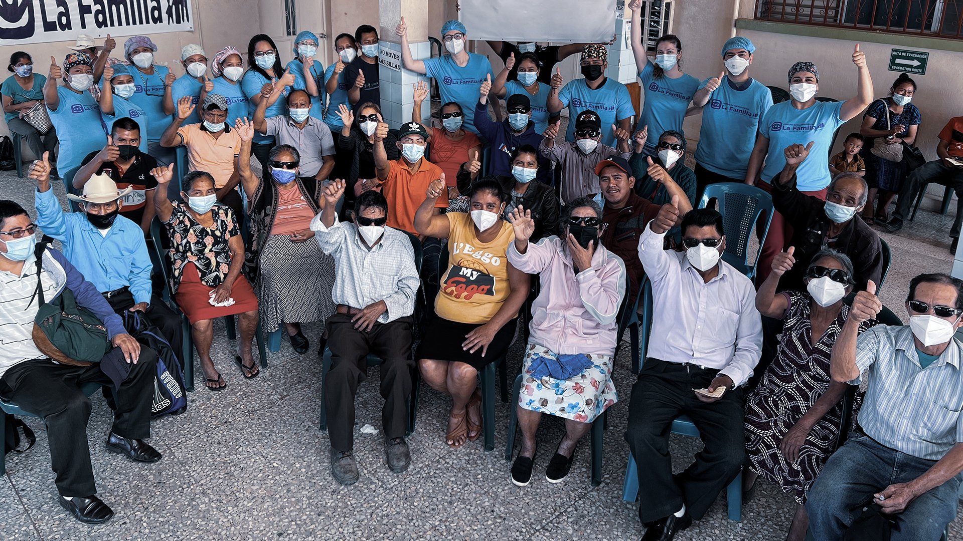 Group of patients, healthcare volunteers and staff from La Familia Eye Center gathered during a community eye care outreach programme