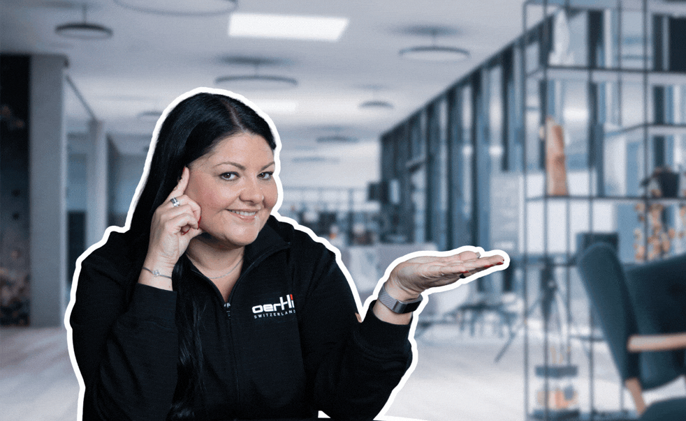 Oertli employee presenting the #oertlispirit graphic in an office setting