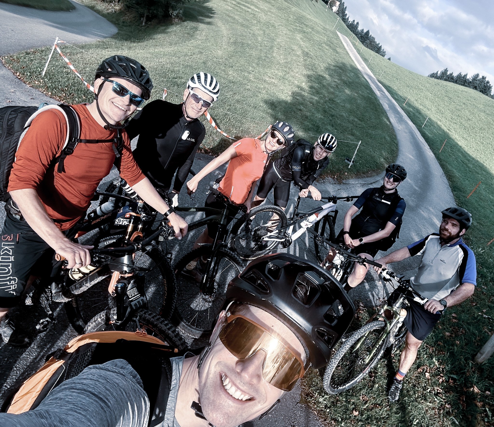 Oertli Mitarbeitende machen während einer gemeinsamen Bike-Tour ein Gruppenfoto in ländlicher Umgebung