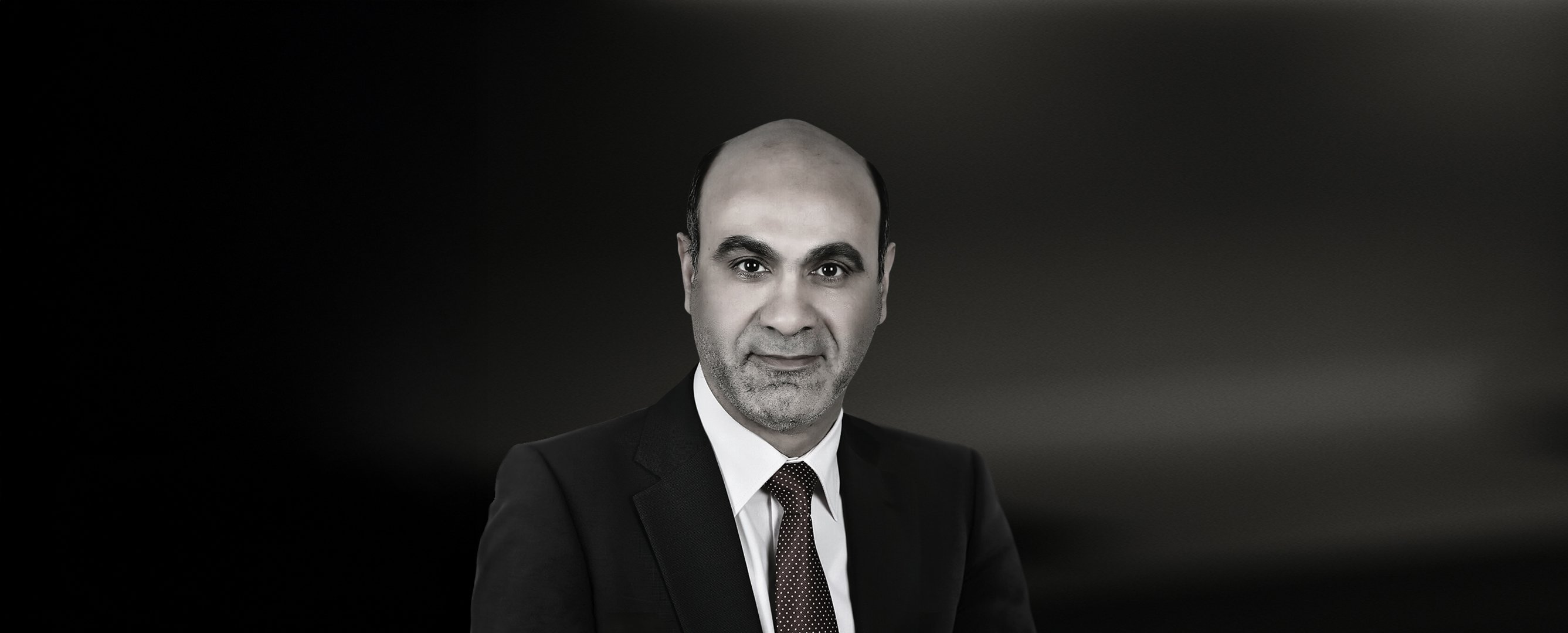 Portrait of Dr Mahmoud Genaidy from Minia University, Egypt, smiling and wearing a suit against a dark background