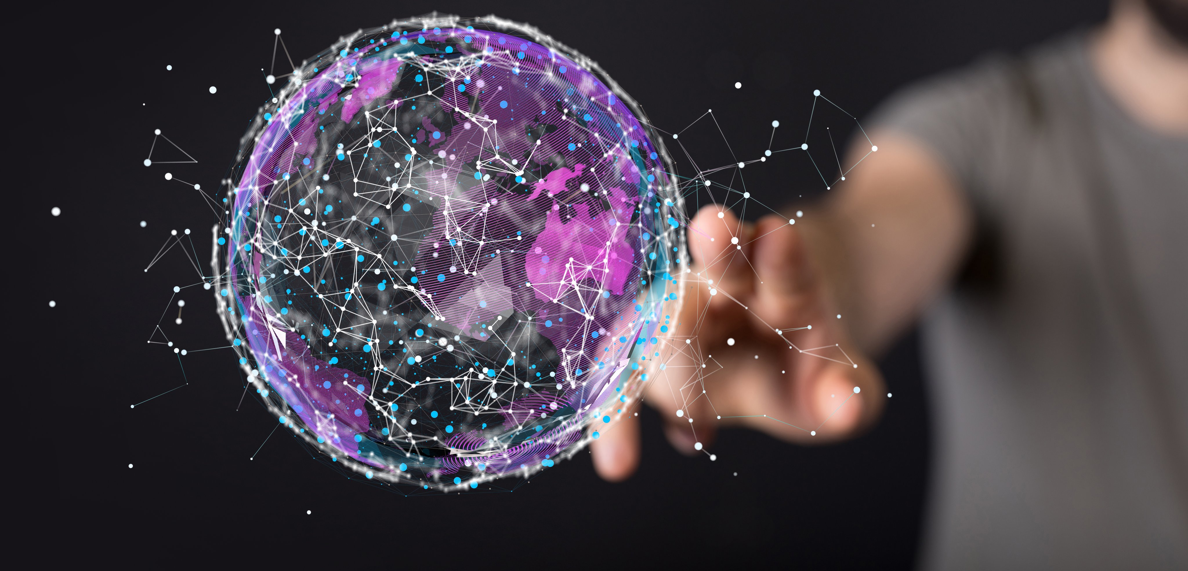 A 3D rendering of a futuristic sci-fi inspired globe with a real person reaching to it in the background