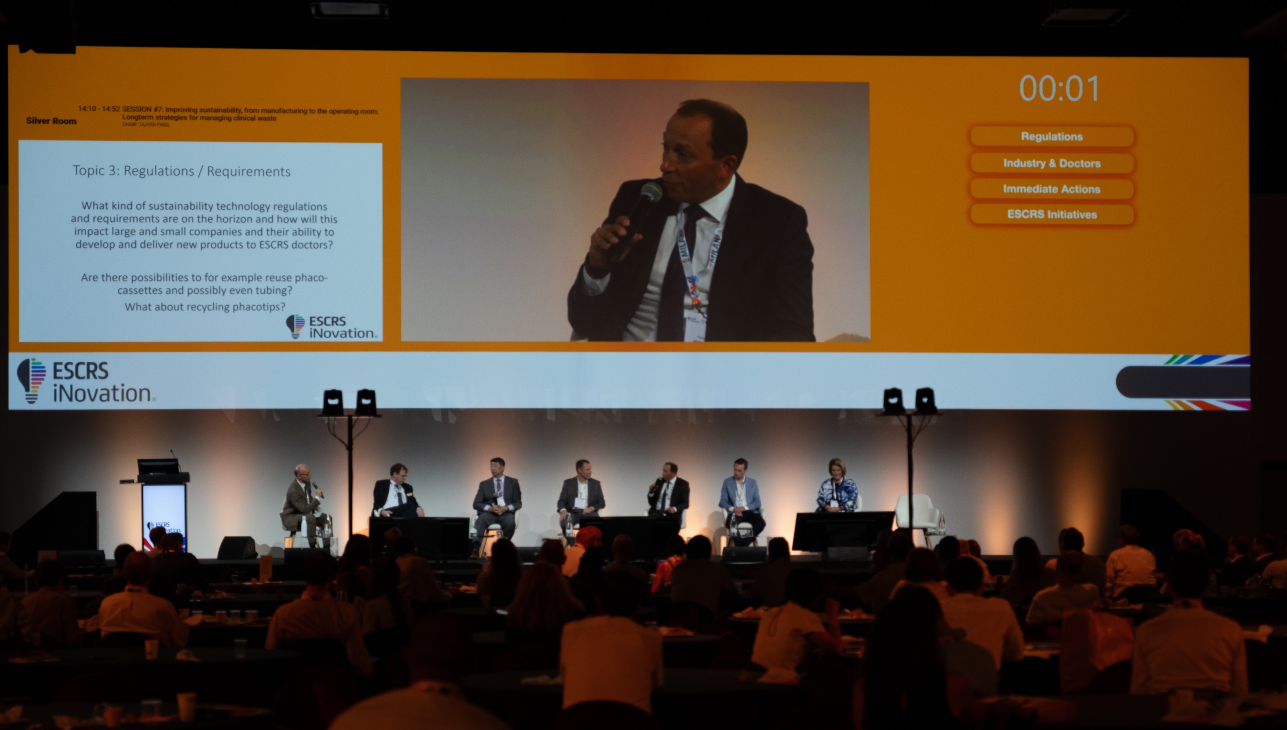 ESCRS iNovation panel discussion on stage, with speakers addressing sustainability and regulatory topics in ophthalmology