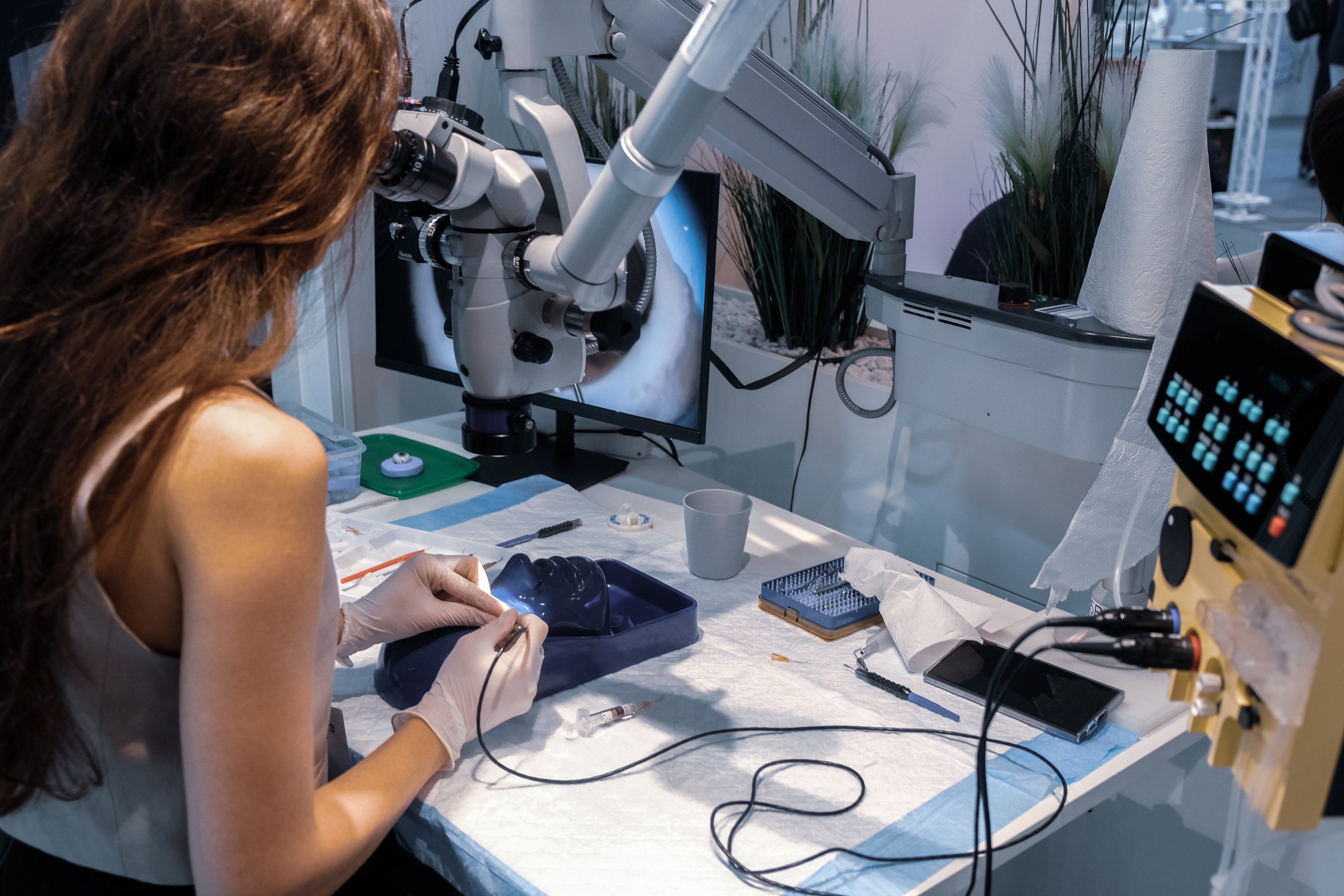 Participant practising surgical techniques at an ESCRS 2023 wetlab station with microscope and Oertli surgical platfor