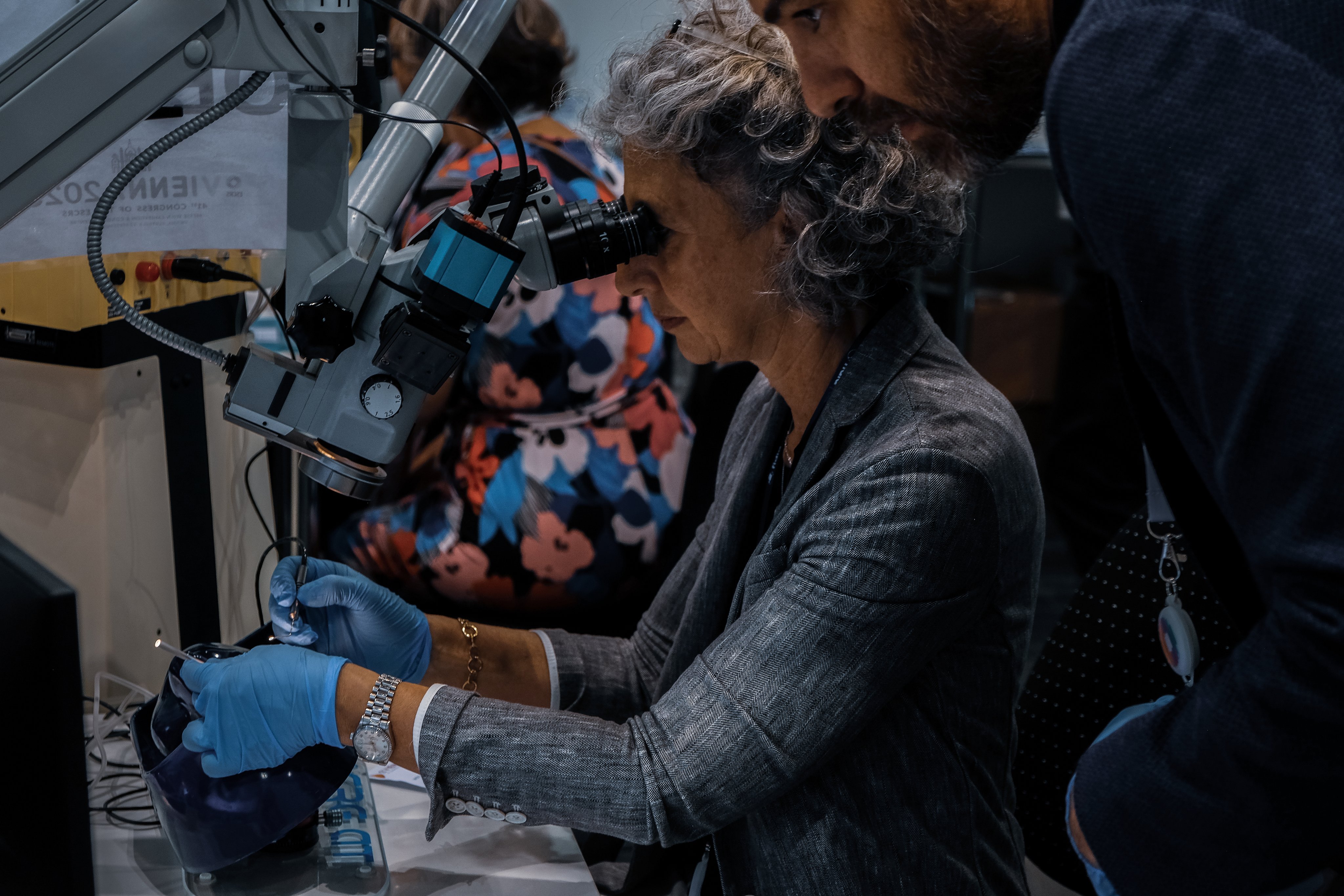 Participant practising at a microscope during a MIGS drylab at ESCRS 2023, guided by an instructor