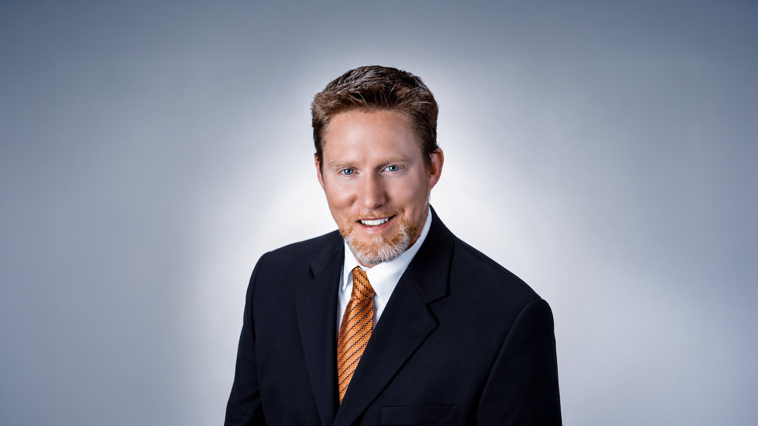 Professional portrait of ophthalmologist Kevin Barber, MD, wearing a suit and tie