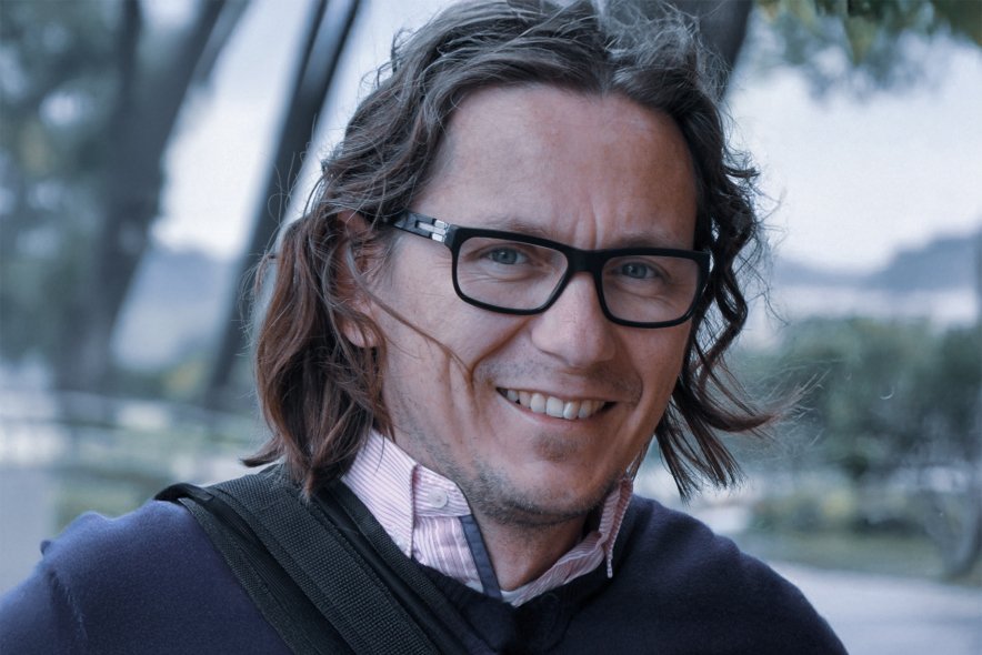 Portrait of a smiling ophthalmologist wearing glasses in an outdoor setting