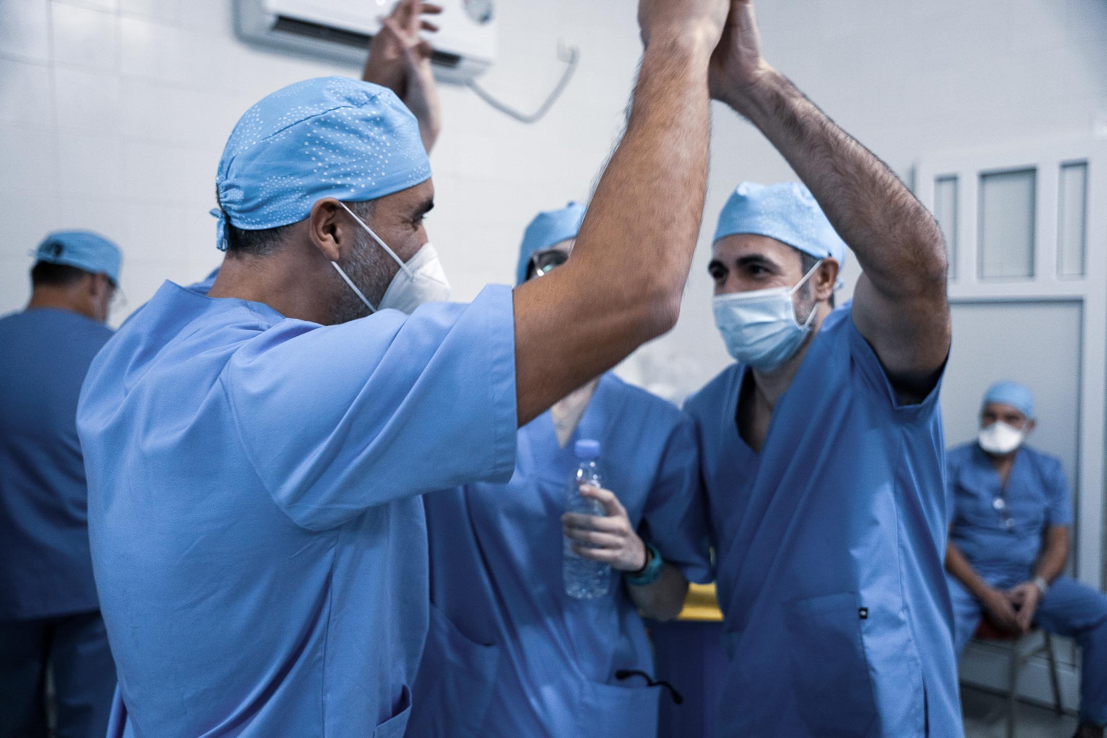 Surgical team celebrating with a high-five during a Fundación Elena Barraquer ophthalmic outreach programme