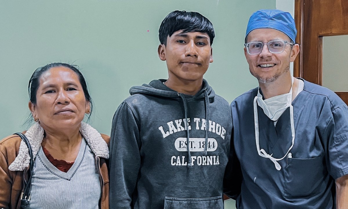 International Eye Institute surgeon with a young patient and an accompanying adult in a clinic setting
