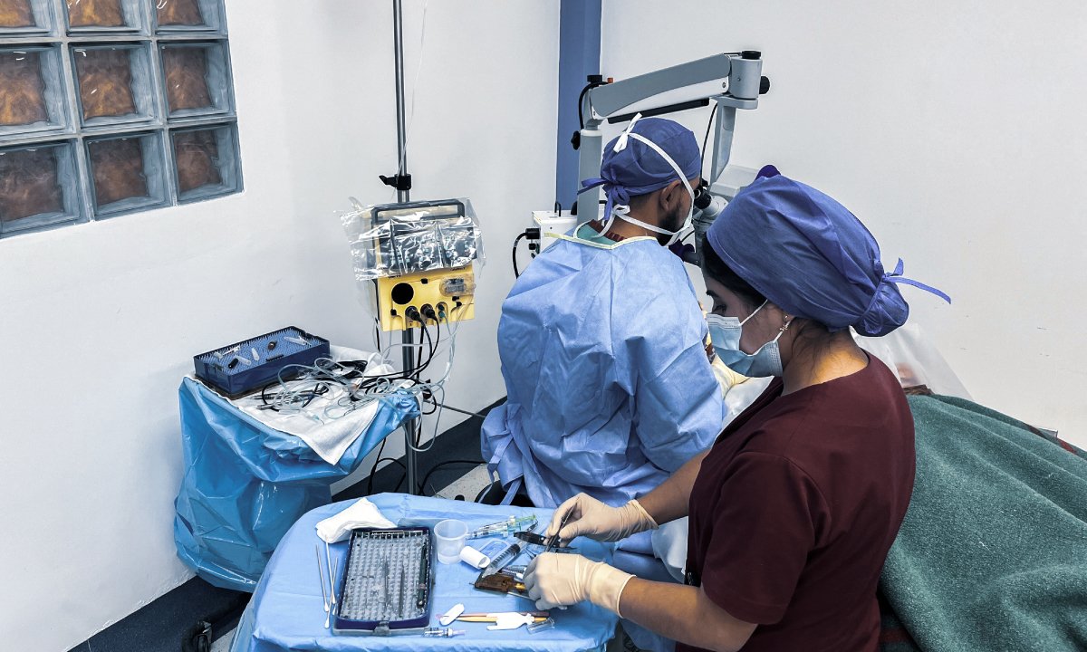 Surgical team performing eye surgery during an International Eye Institute charity mission, with an Oertli CataRhex 3 system in the operating room