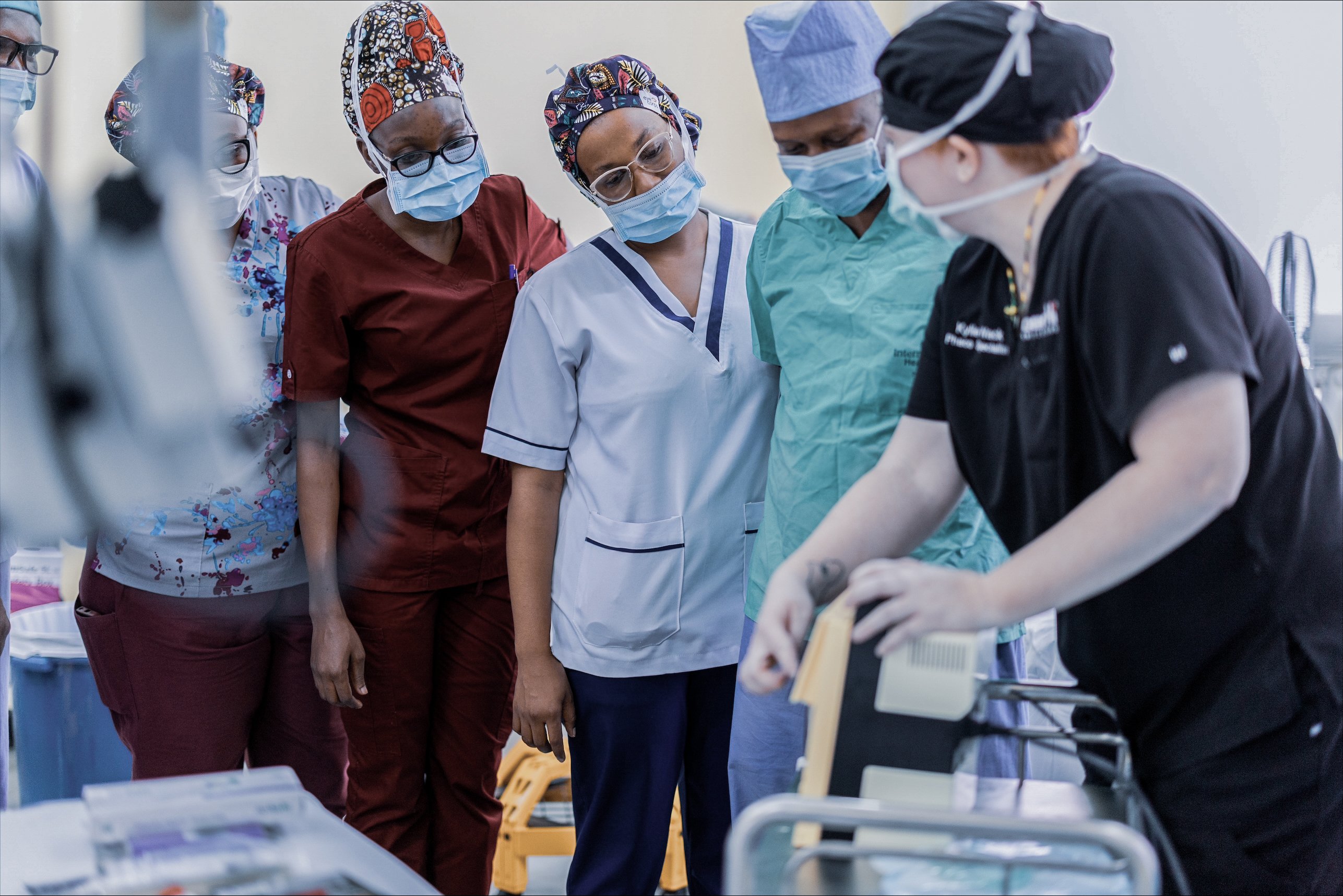 Healthcare professionals observe a surgical training session during an eye care outreach programme