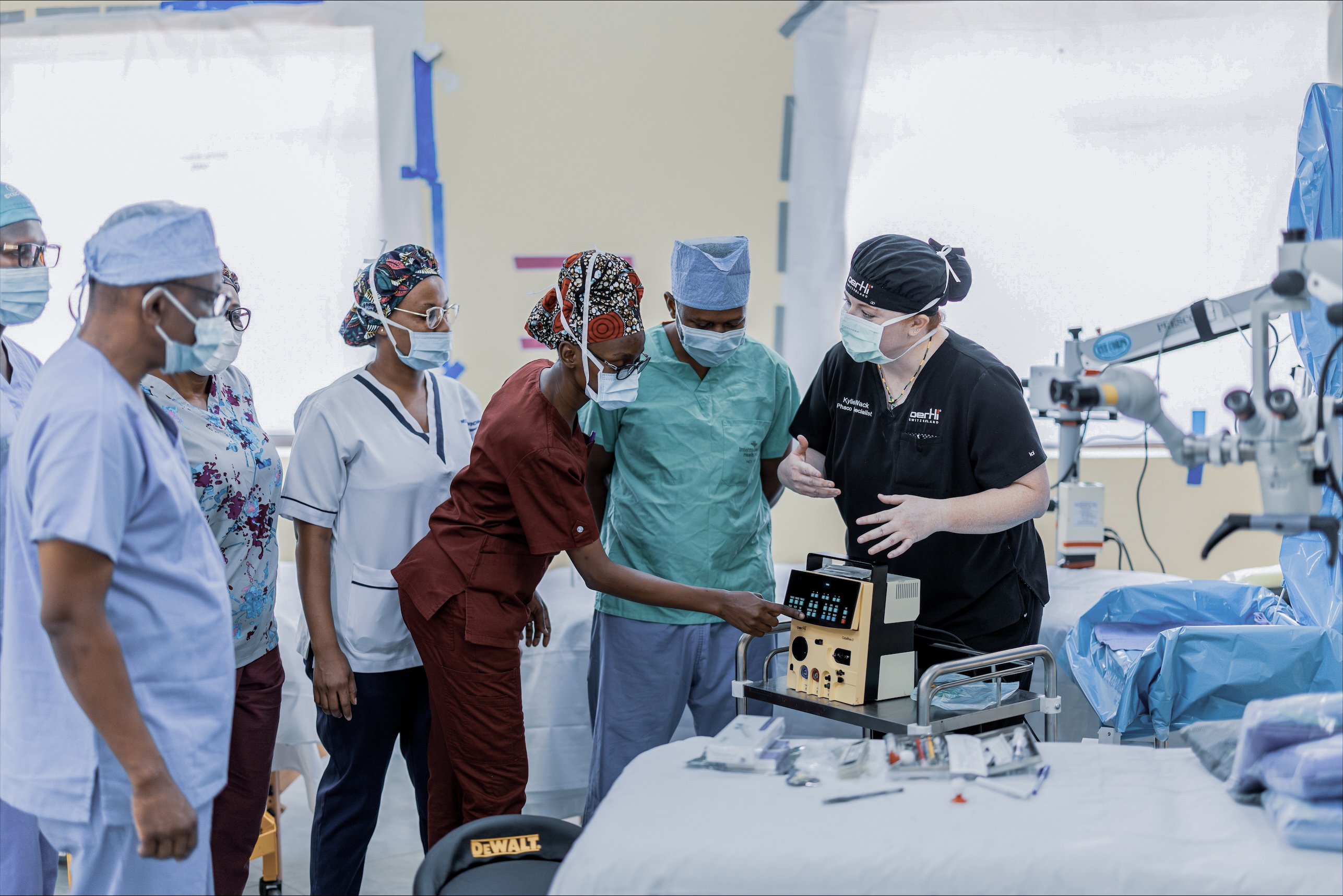 Medical professionals gathered around a CataRhex 3 system during an ophthalmic outreach training session in Tanzania
