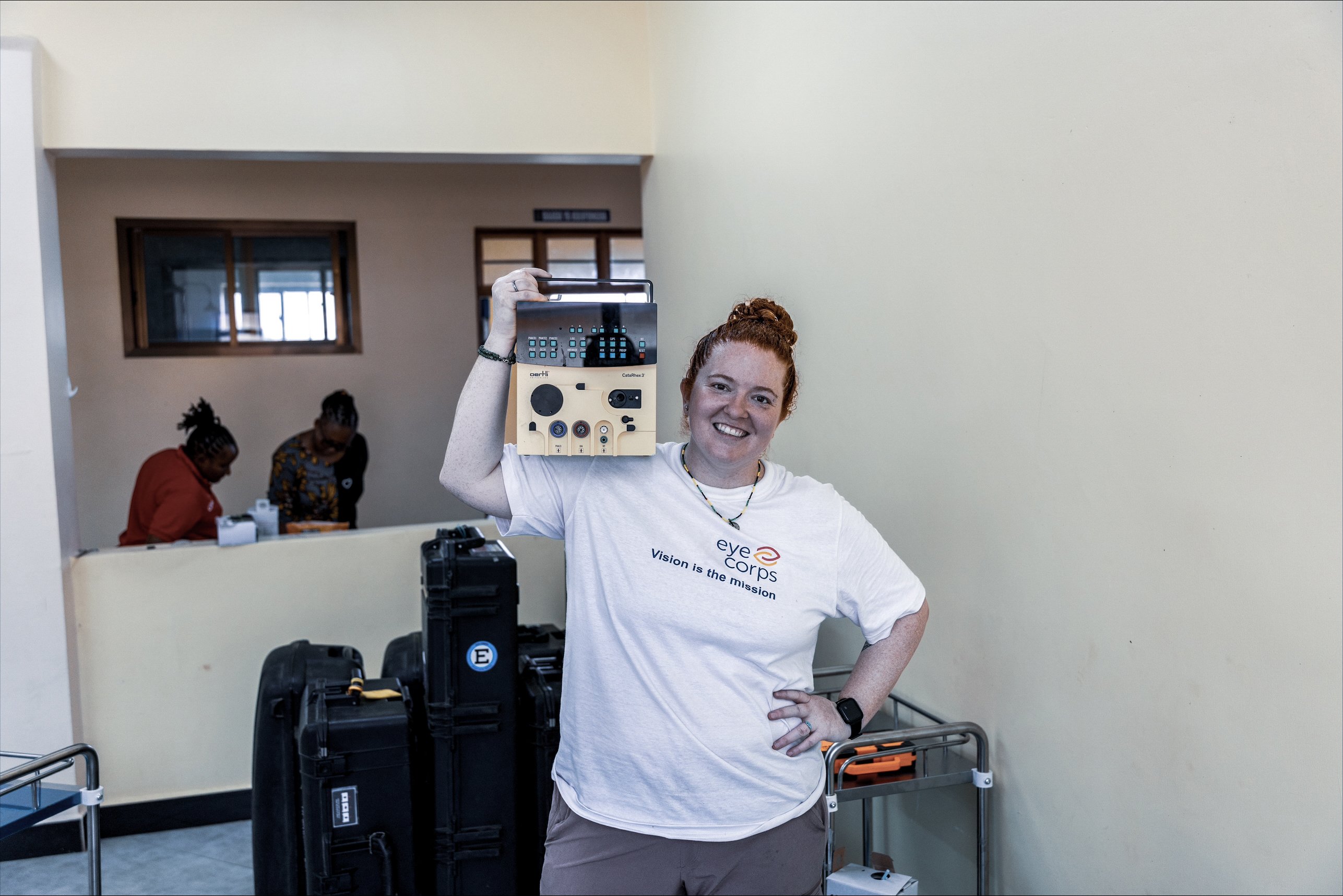 Eye Corps volunteer holding a portable cataract surgery system during an outreach mission in Tanzania, supporting access to eye care and cataract treatment in remote communities
