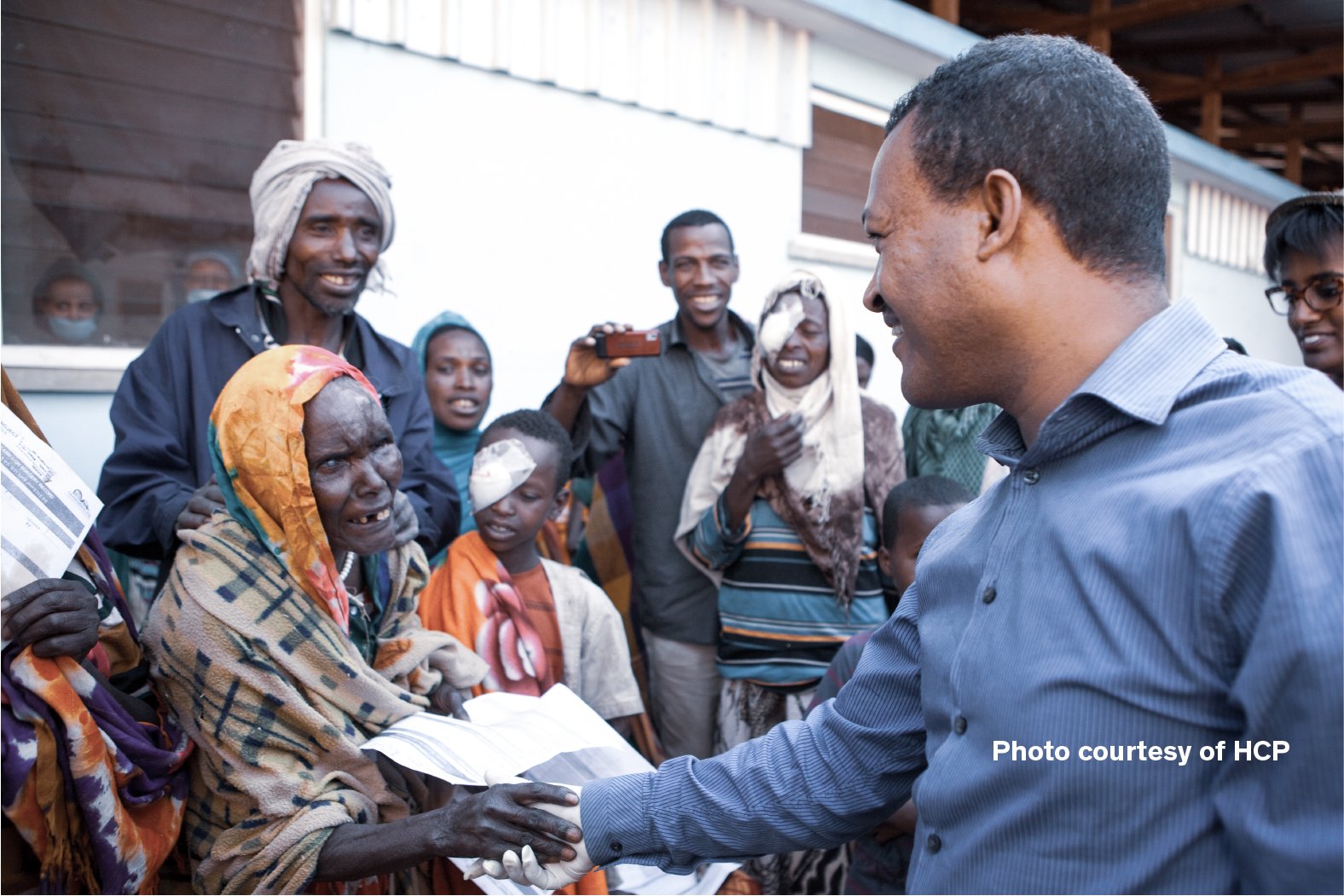 Community members and healthcare partner celebrating after an ophthalmic outreach programme supported by Cure Blindness