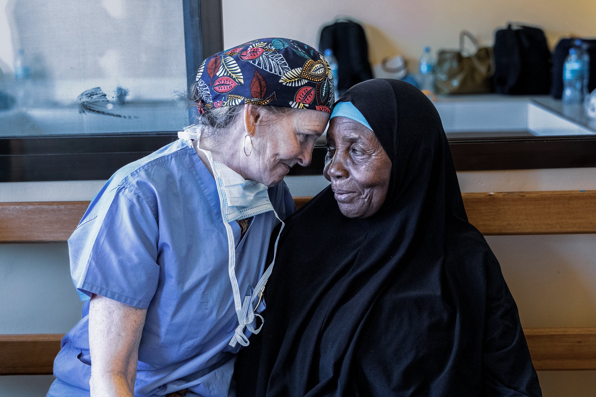Eye care professional and patient sharing a personal moment during a charitable ophthalmic outreach programme in Tanzania