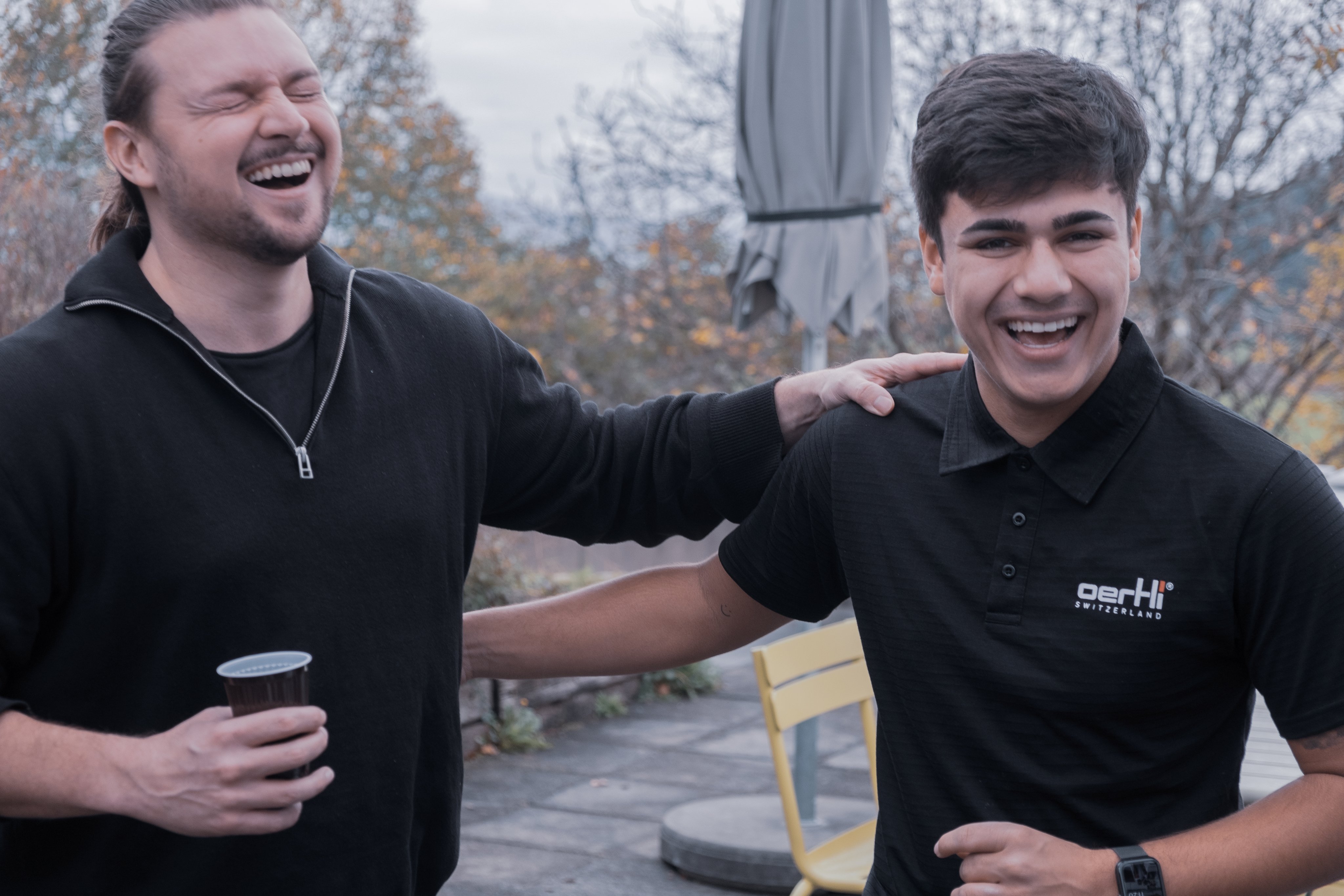 Two Oertli employees laughing together during a welcome event outdoors