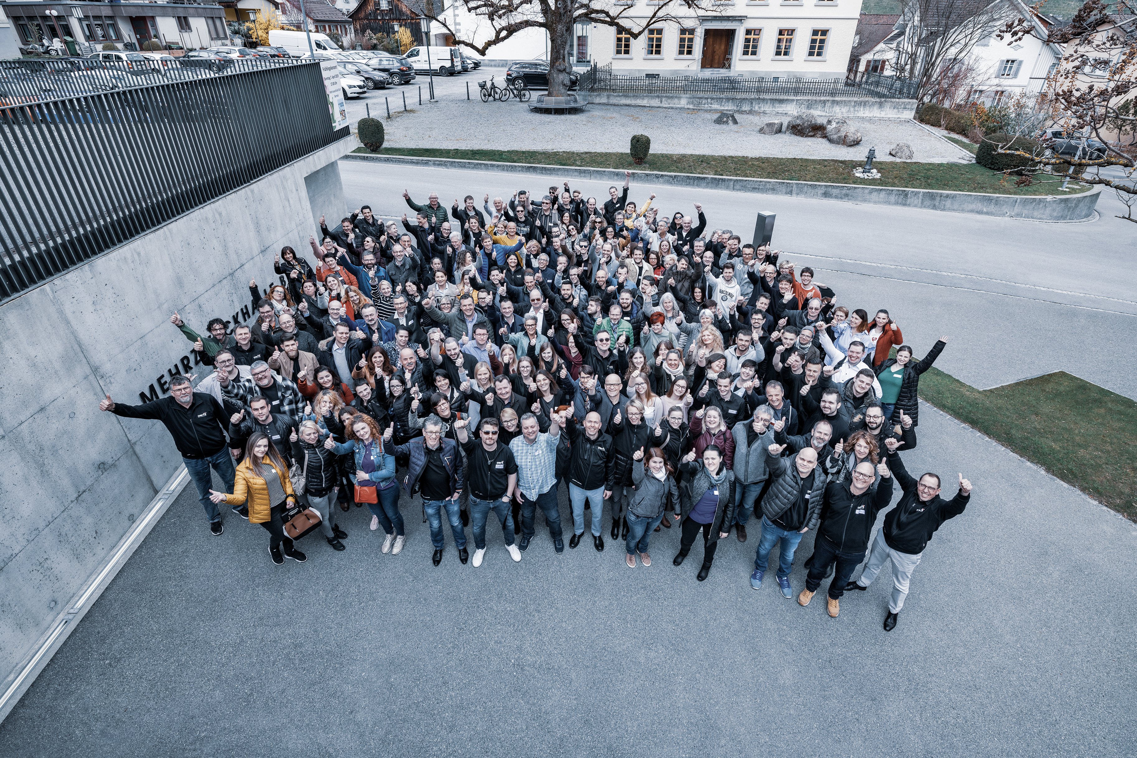 Gruppenfoto von Mitarbeitenden während eines Employer-Branding-Strategietags vor dem Unternehmensgebäude von Oertli