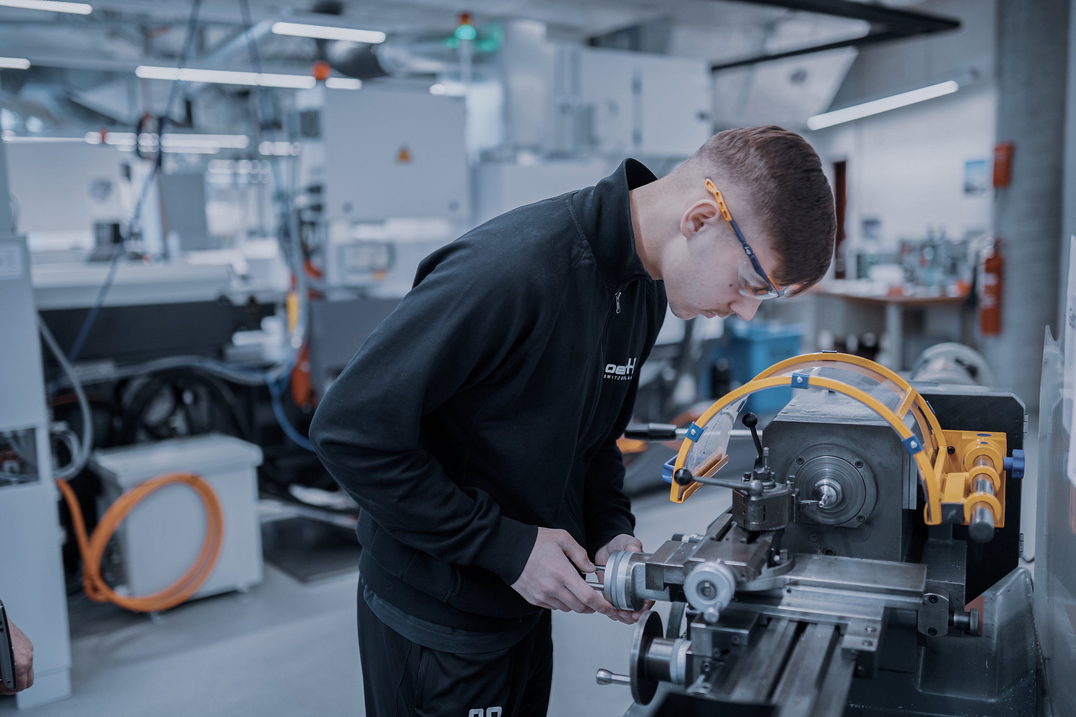 Oertli apprentice operating a production machine during hands-on training in the manufacturing area