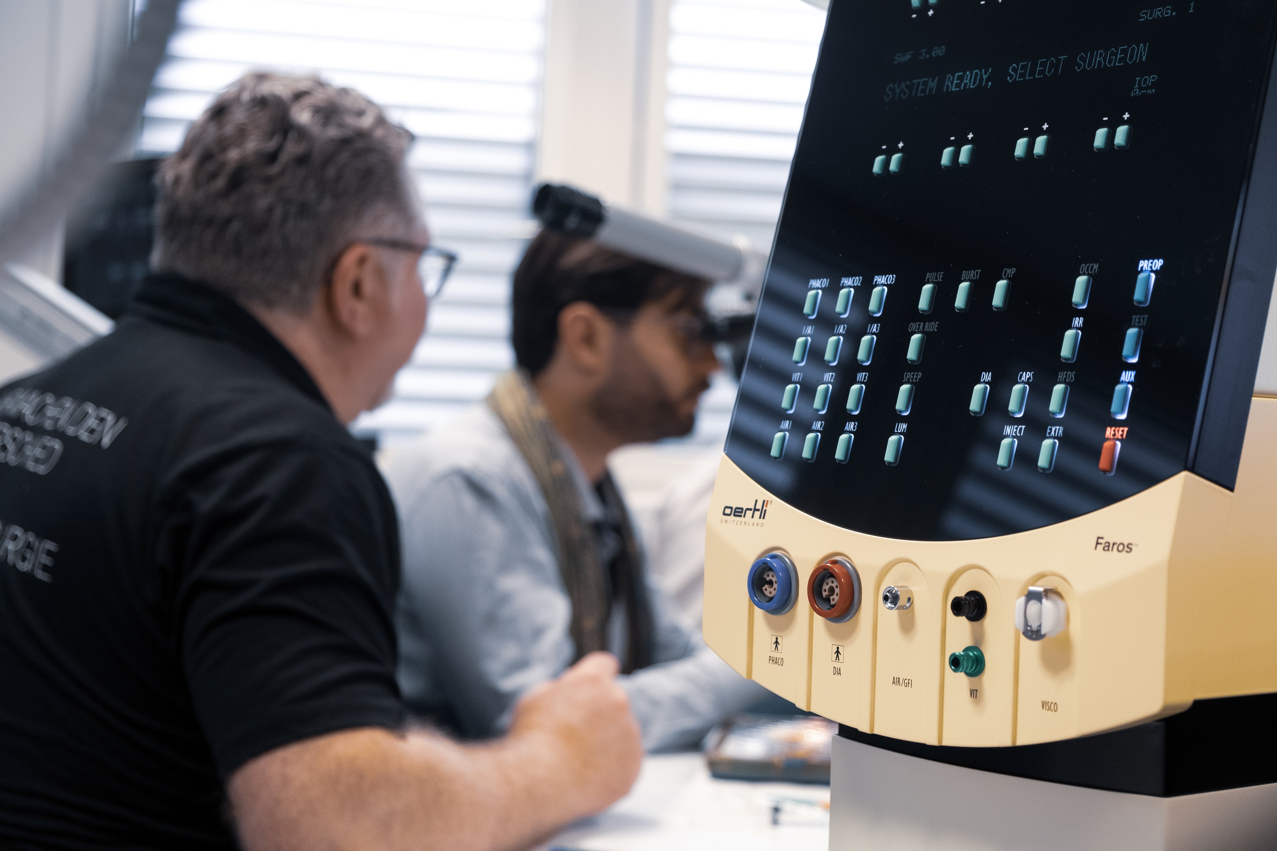 Sales training session with the Faros surgical platform in focus and participants in discussion in the background