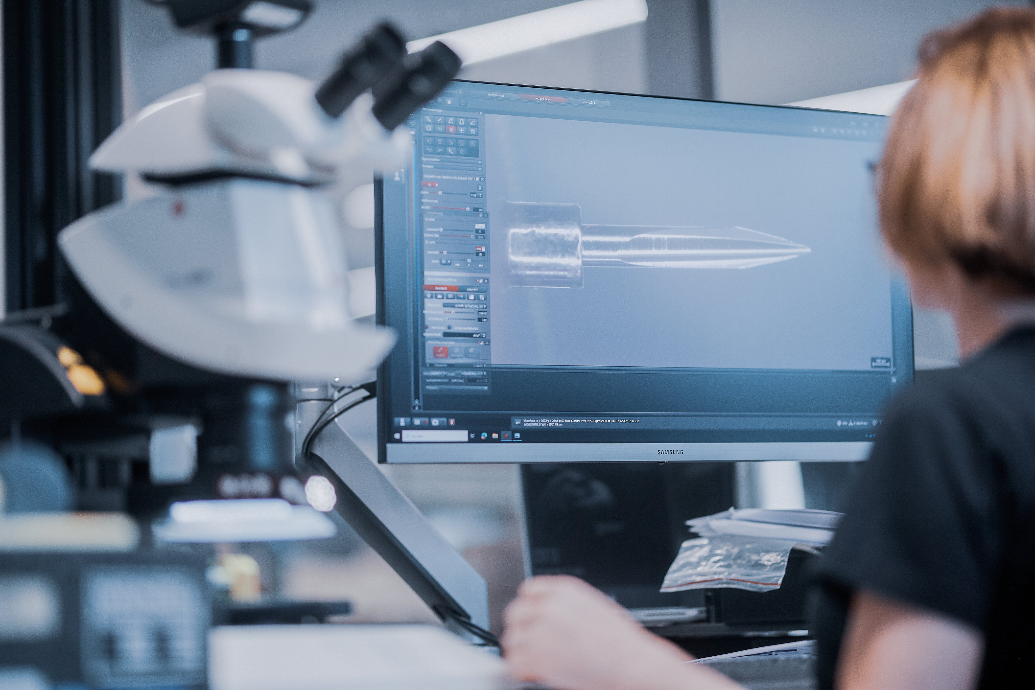 Employee performing incoming goods inspection using a digital microscope and analysis software