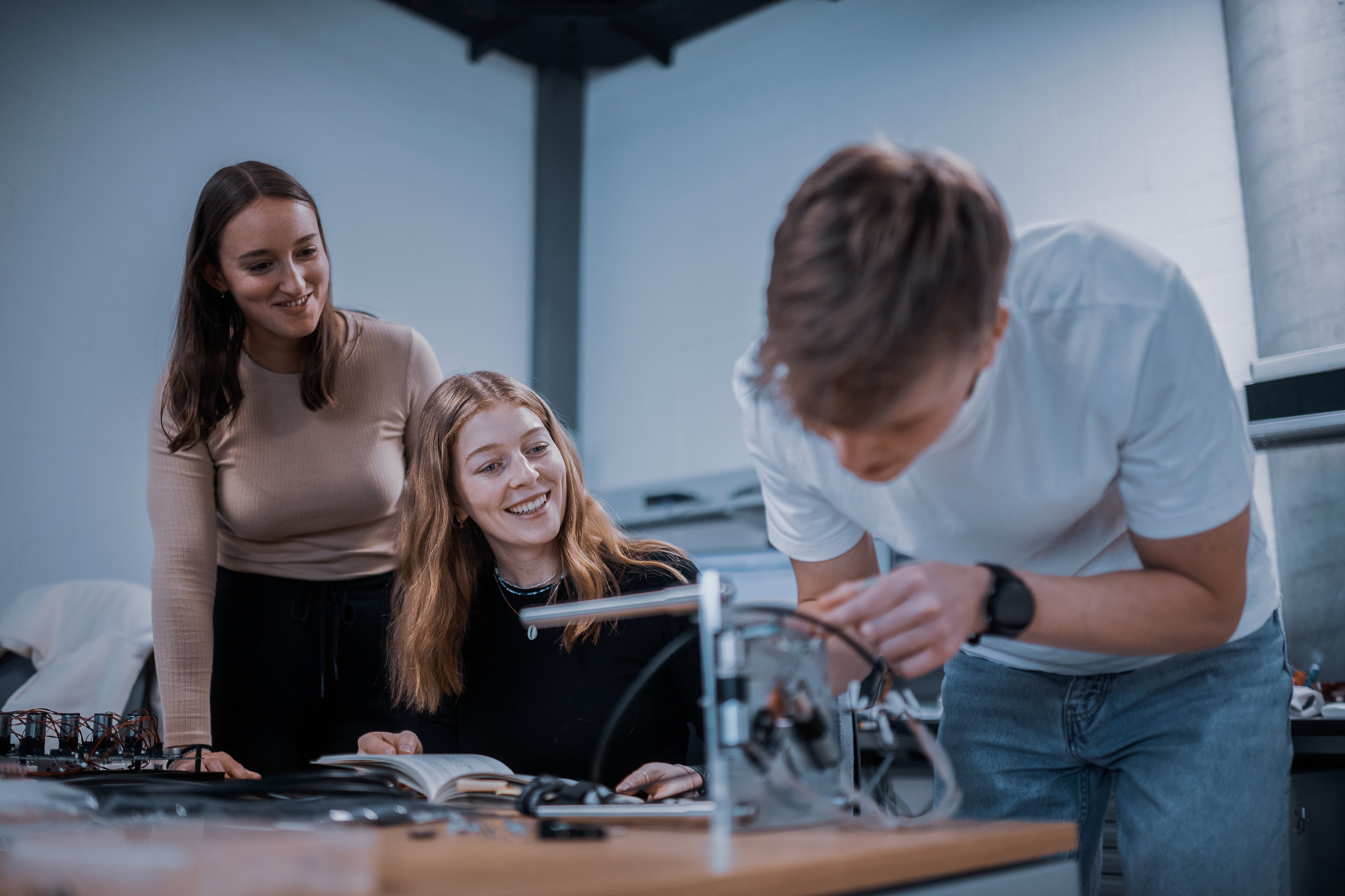 Praktikanten arbeiten gemeinsam an einem technischen Projekt in der Ausbildung