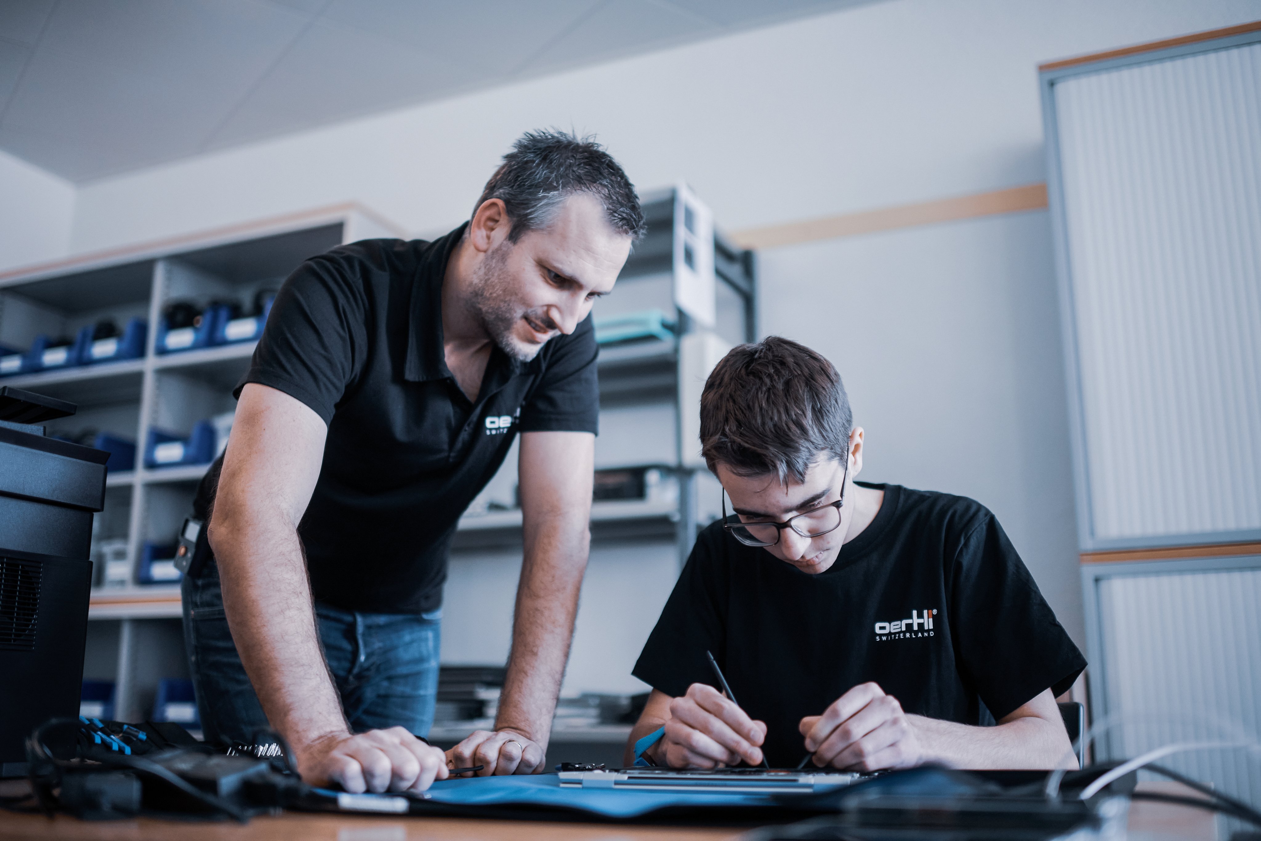 Lehrmeister hilf dem Lernenden bei der Reparatur einer elektronischen Komponente 