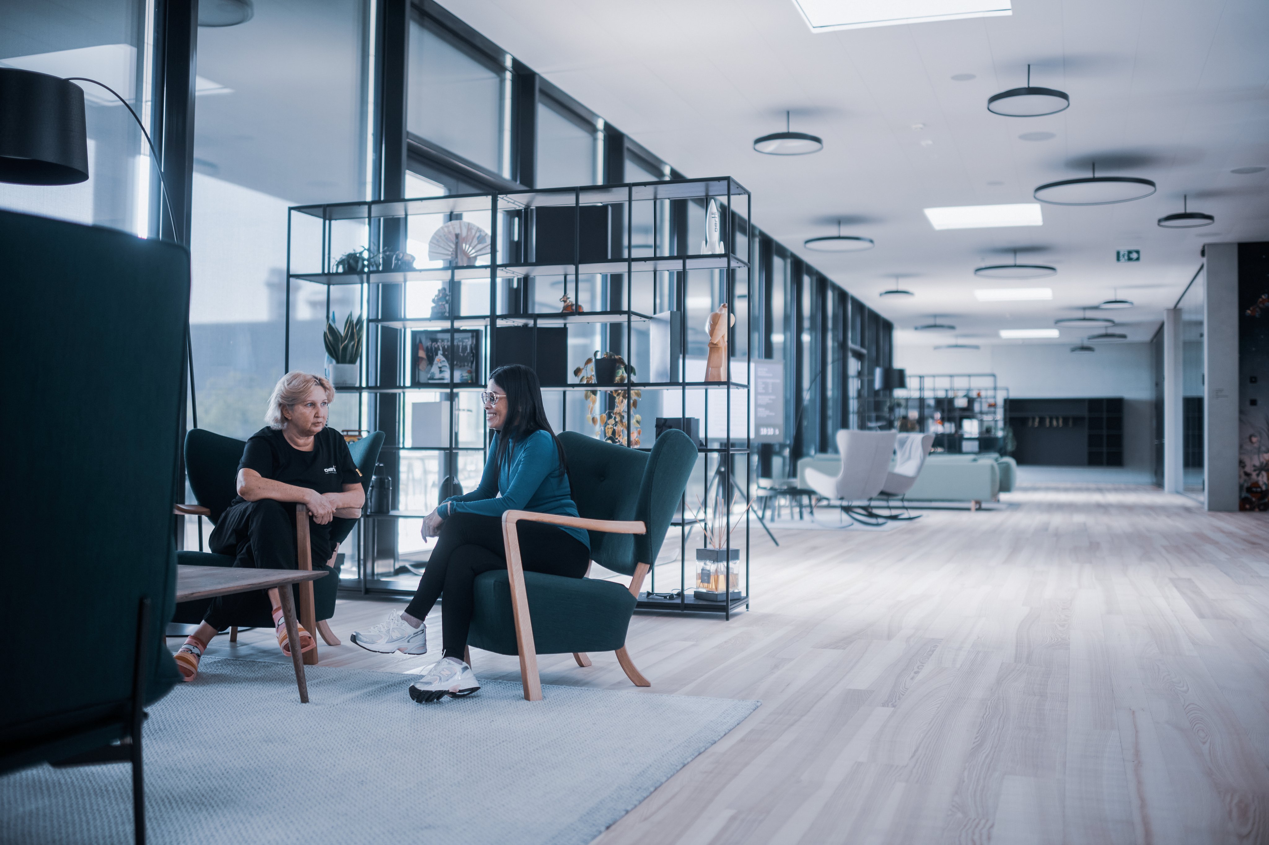 Two Oertli employees talking in a modern lounge area at Oertli Square