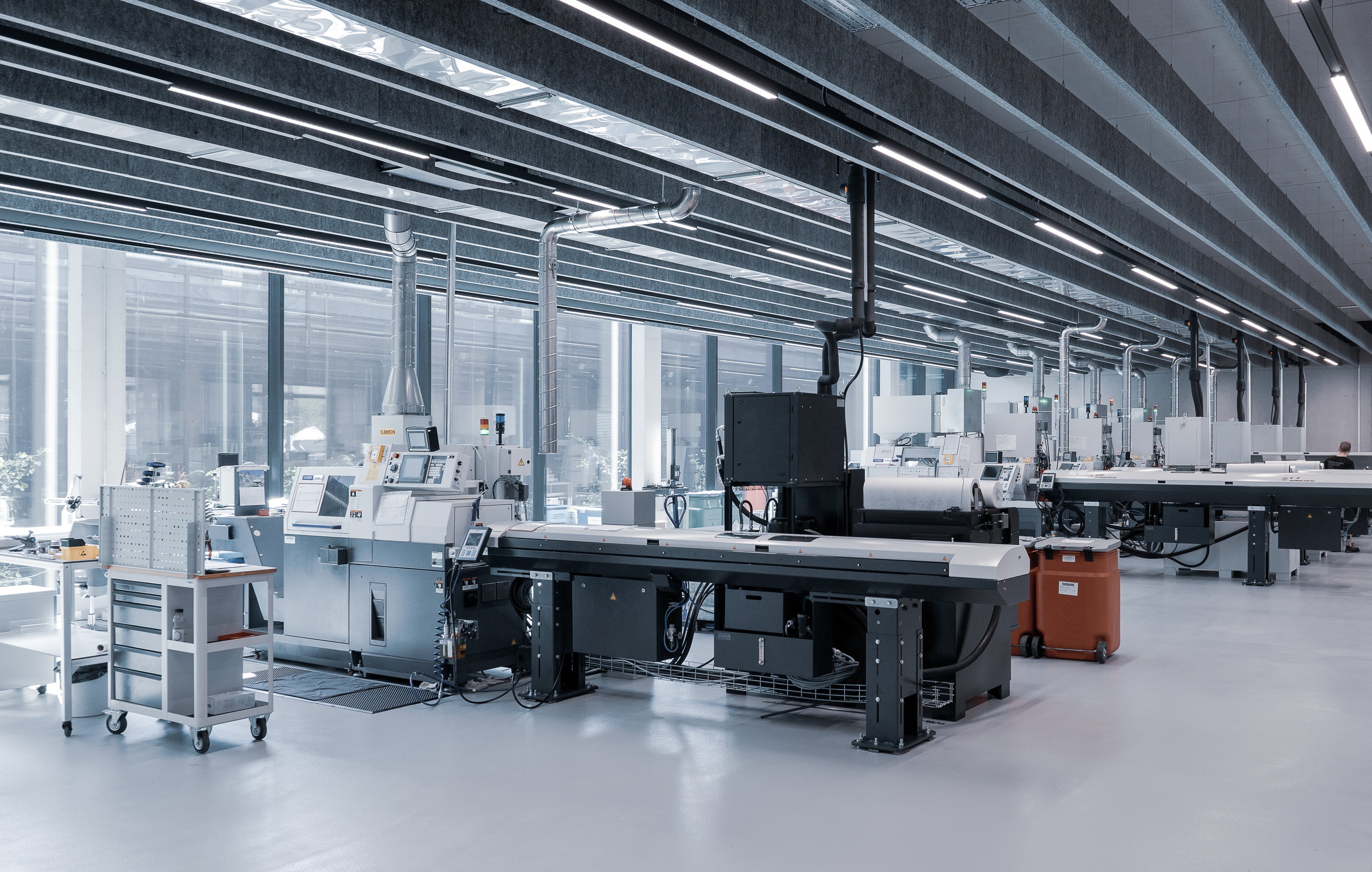 Spacious manufacturing facility with CNC machines and production equipment arranged in a modern industrial environment