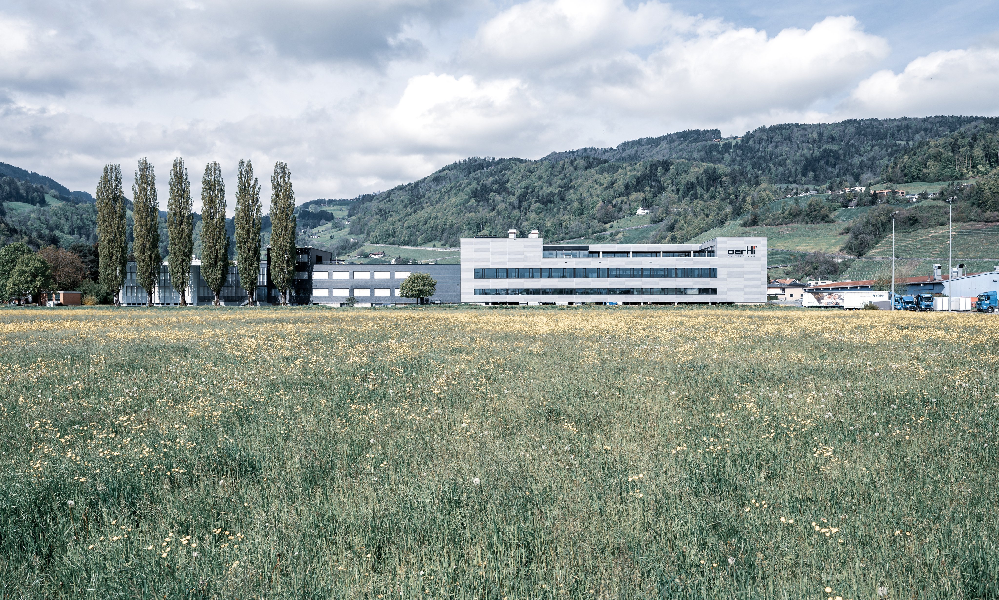 Oertli company building viewed from outside with surrounding landscape and mountains