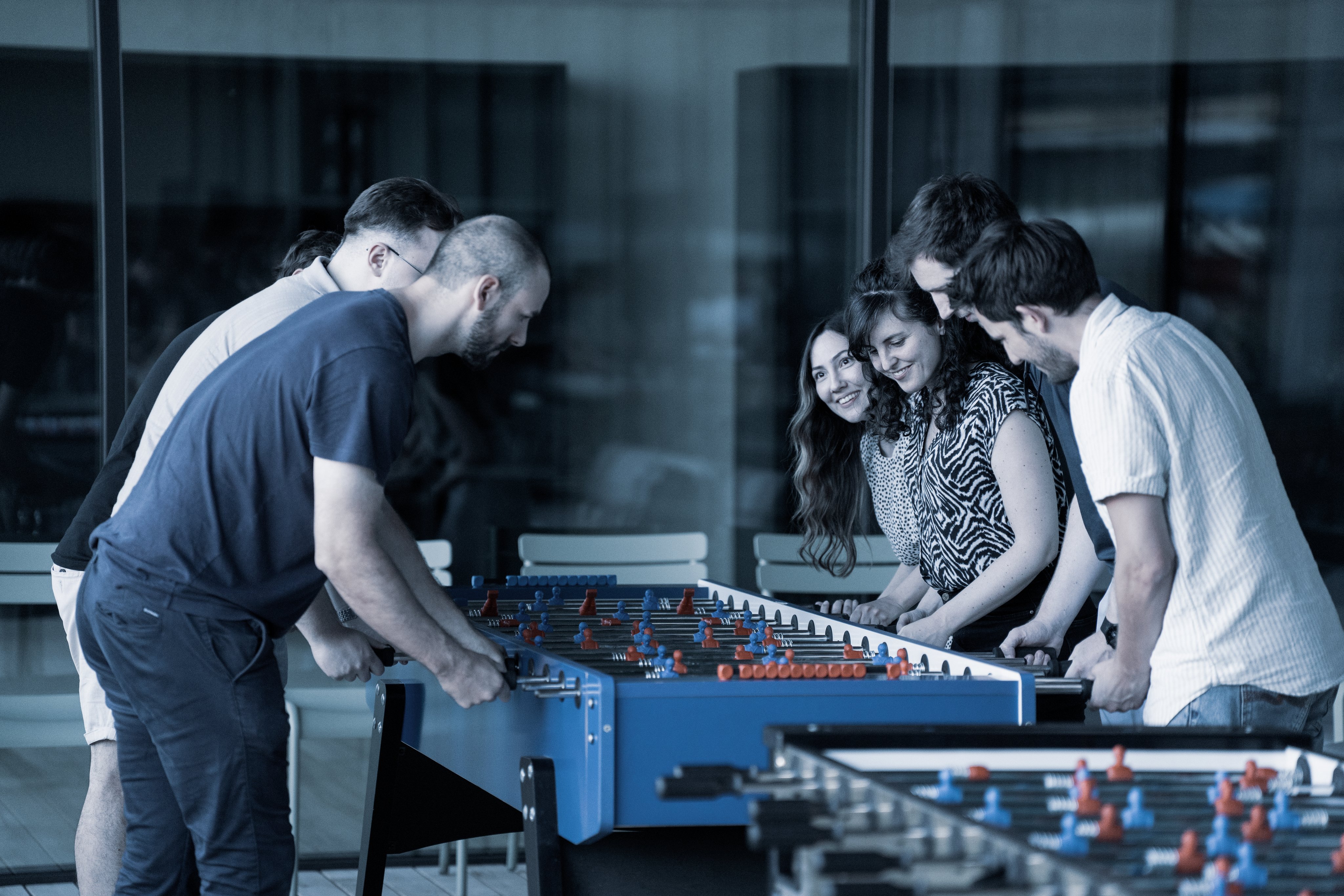 Mitarbeitende spielen gemeinsam Tischfussball bei einem Team- und Employer-Branding-Event in moderner Umgebung