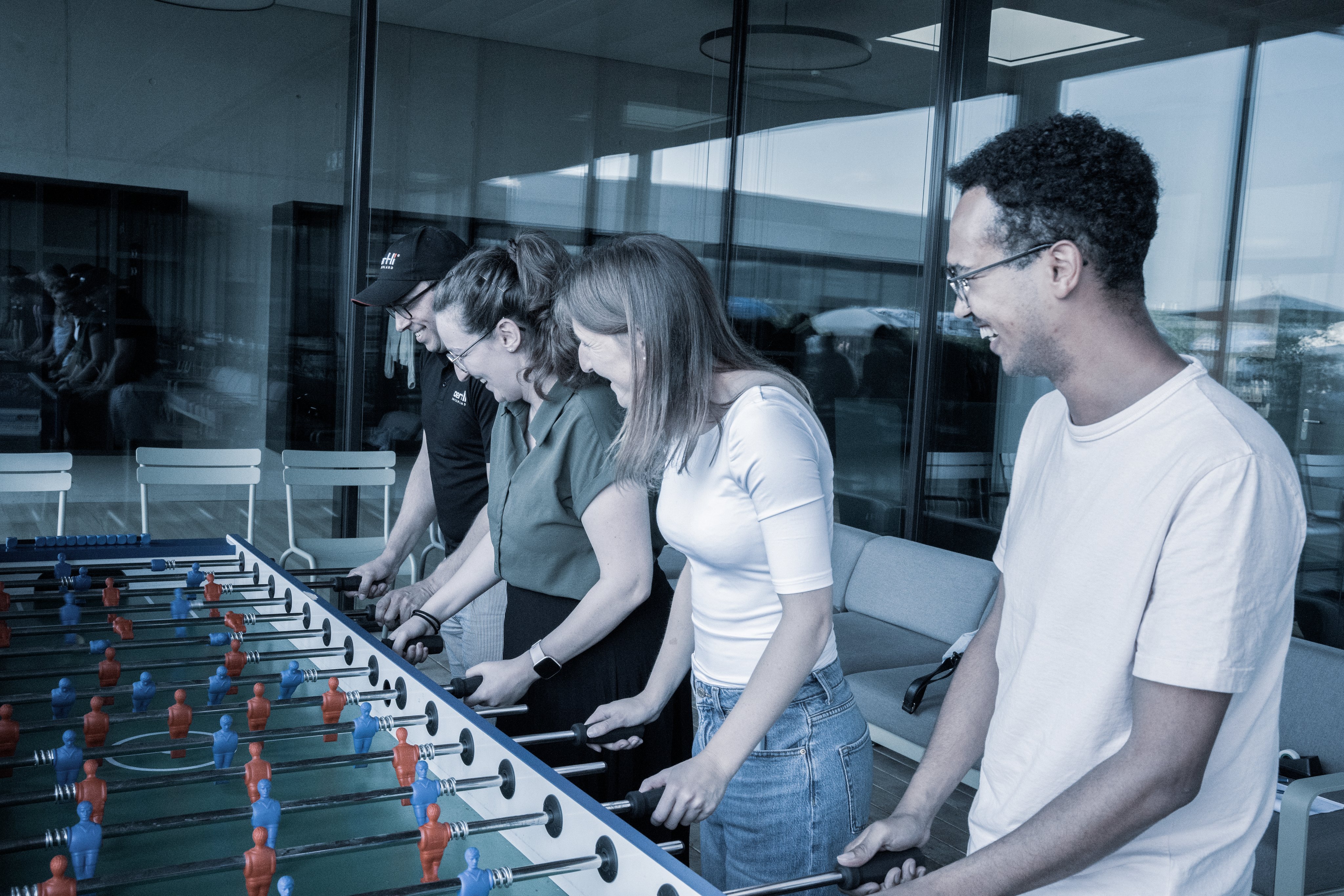 Mitarbeitende spielen gemeinsam Tischfussball beim Sommeranlass und verbringen Zeit miteinander