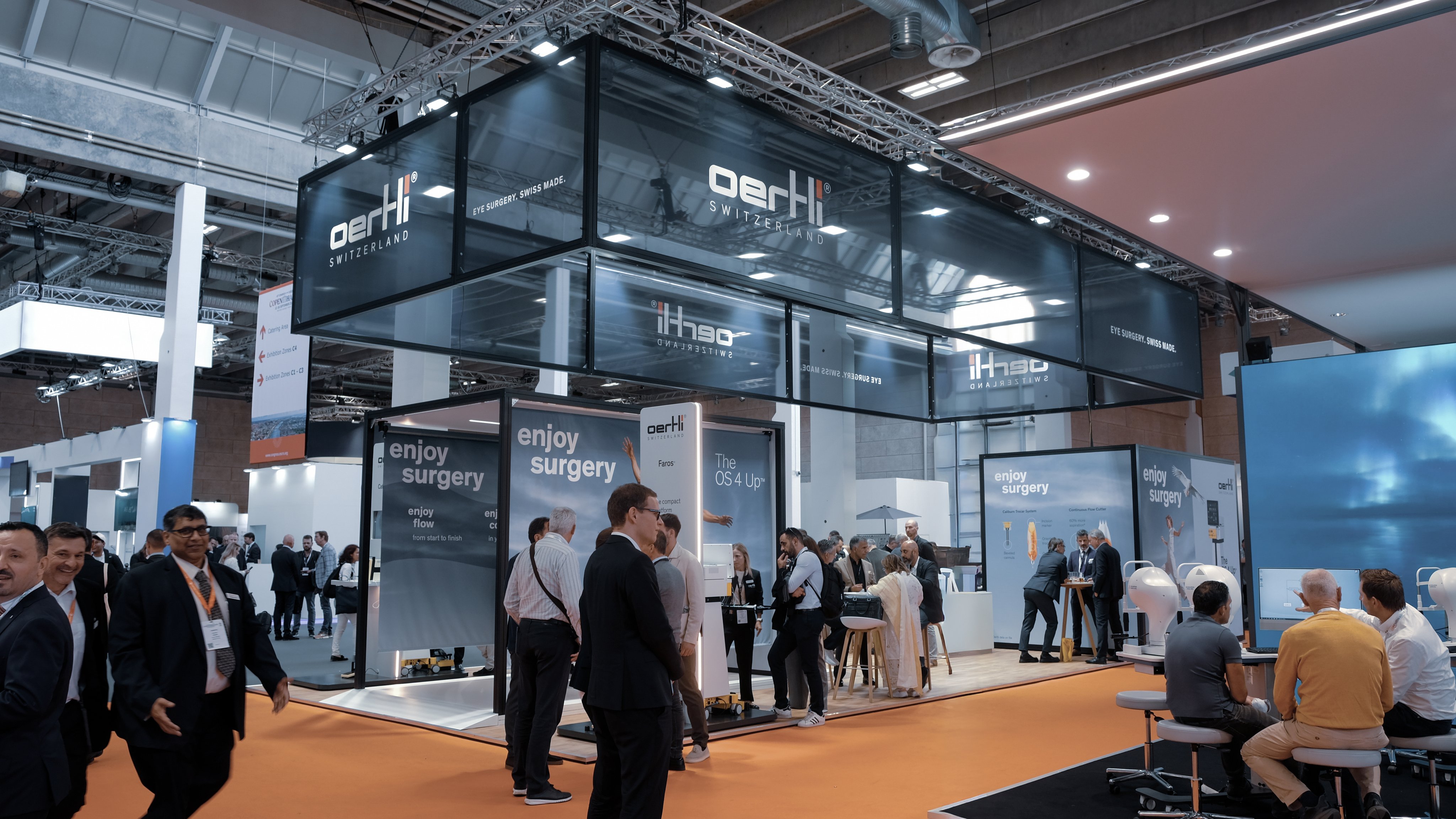 Visitors at the Oertli exhibition booth during ESCRS, featuring ophthalmic surgical systems and interactive product presentations.