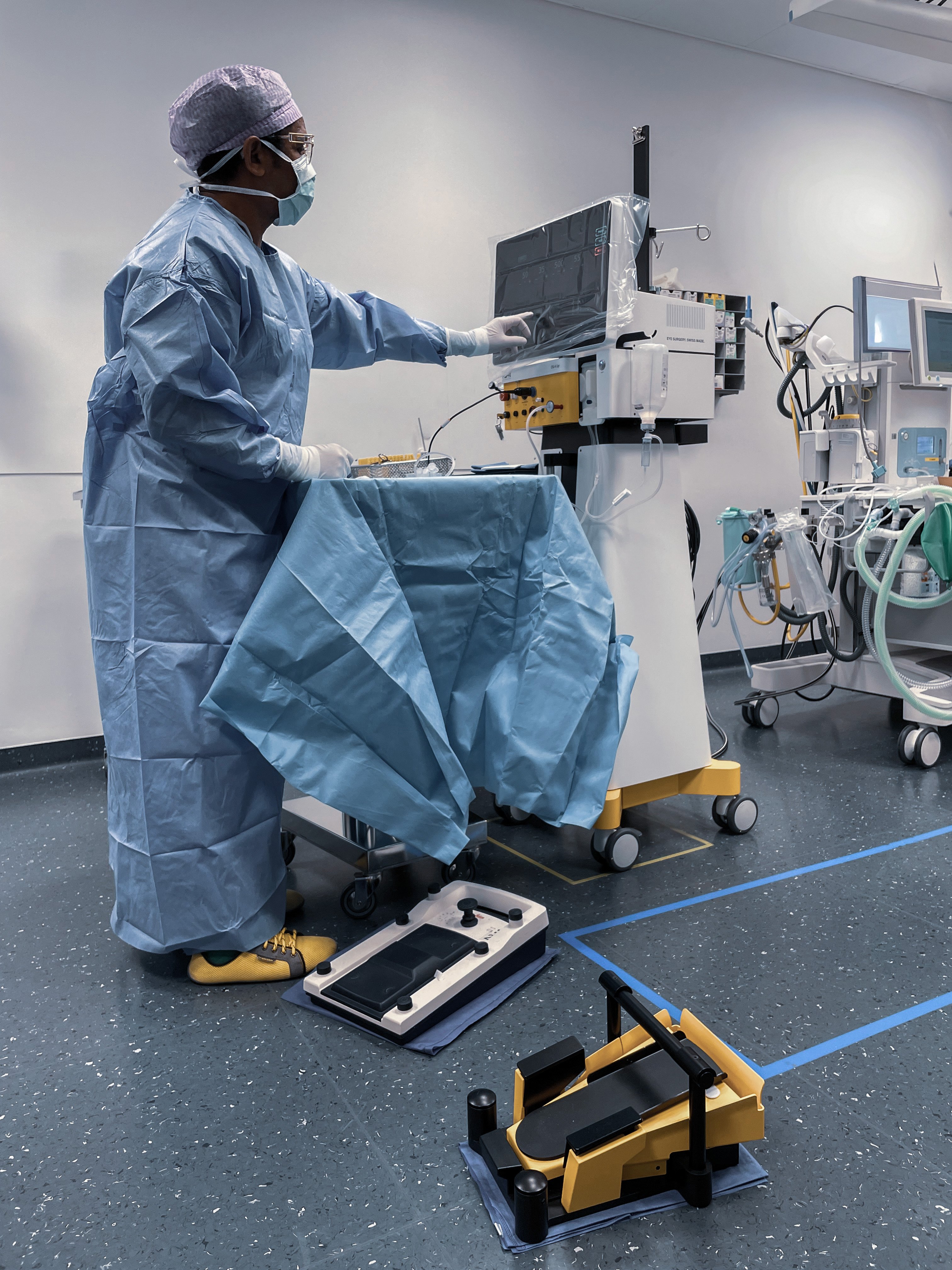 Surgeon in an operating room adjusting the OS 4 Up surgical platform with foot pedal controls in the foreground