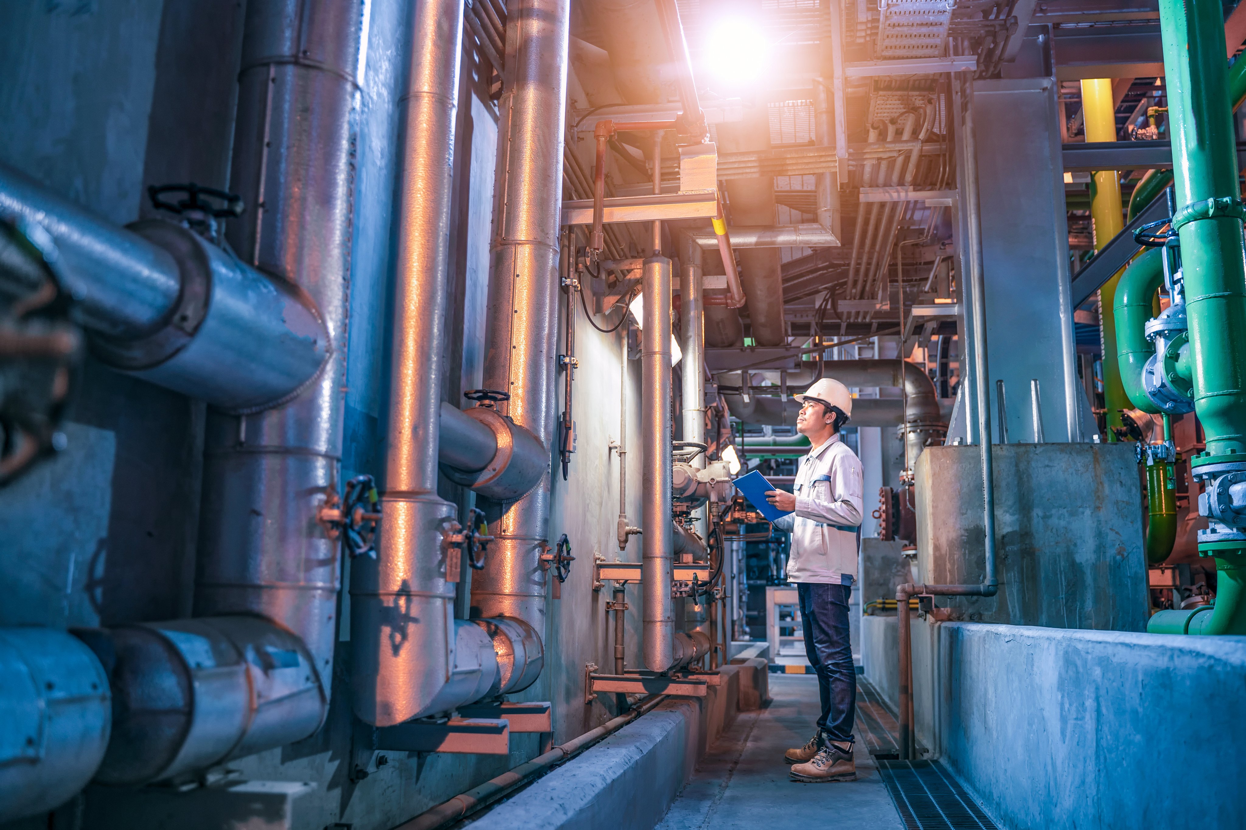 Engineer check status work at factory, Industrial zone steel pipelines and valves, engineer maintenance equipment at power plant.