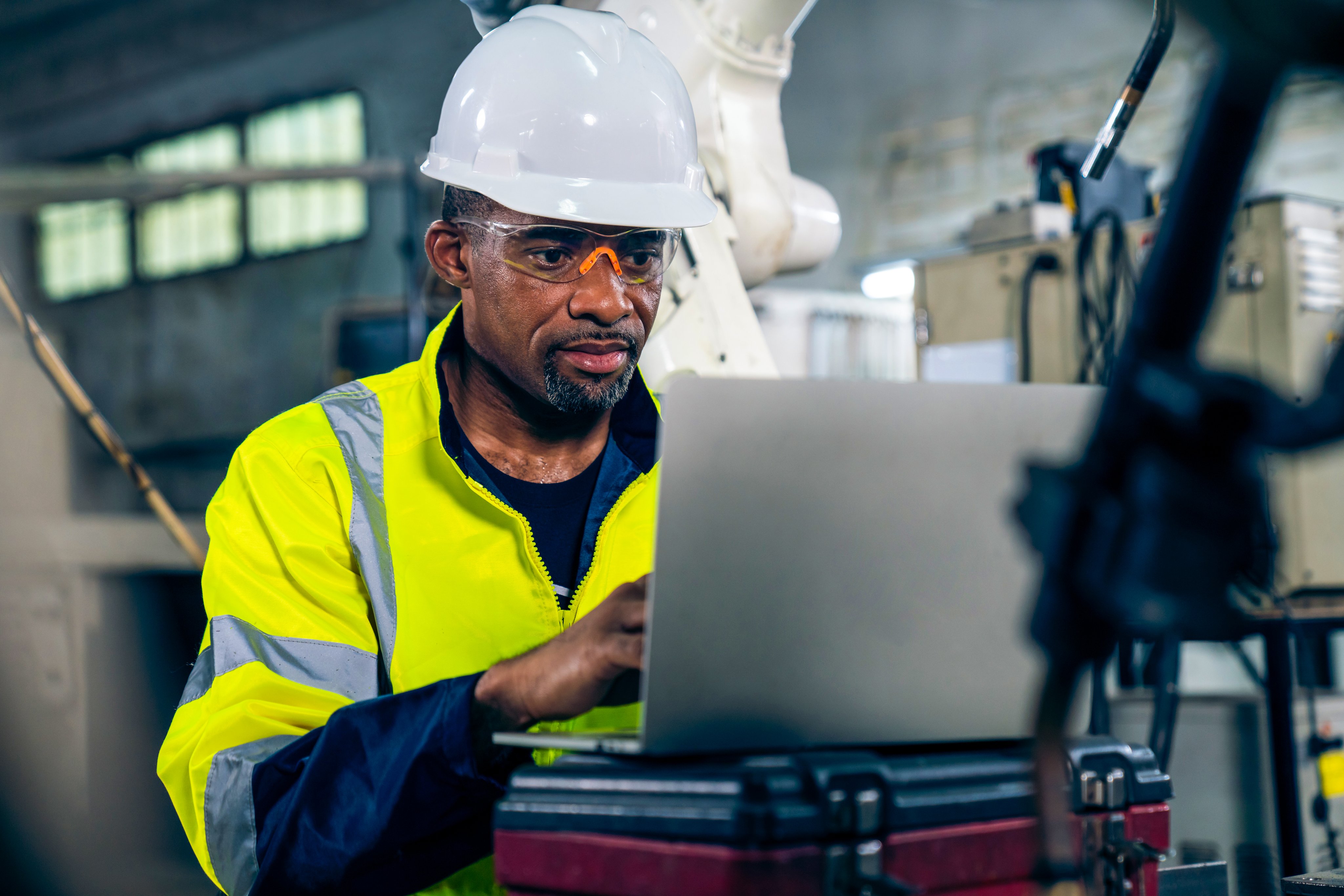 Factory worker working with laptop computer to do adept procedure checklist . Factory production line operator occupation quality control concept .