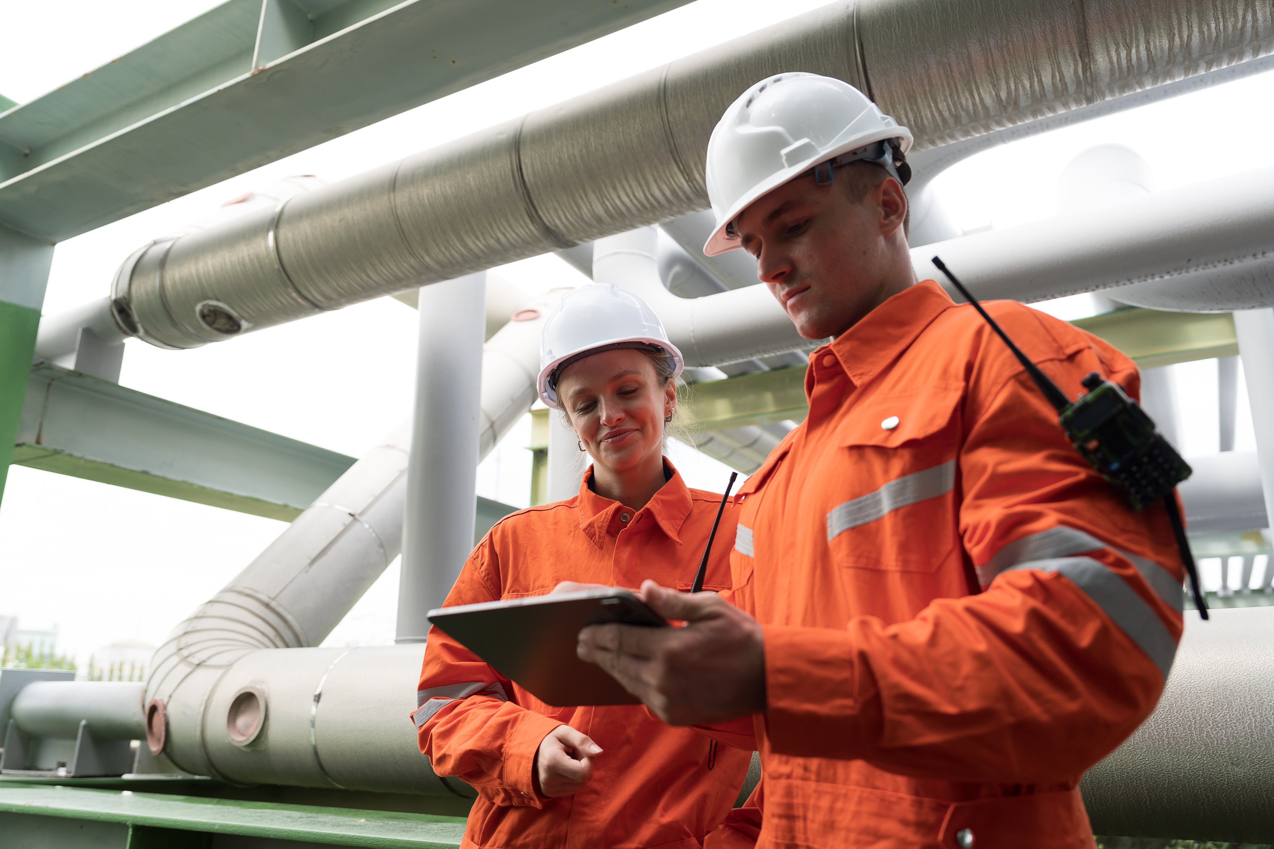 Petroleum Refinery. Oil refinery. Gas pipeline network system. Petrochemical engineer working, discussing and inspecting gas pipeline, valves and mechanisms deliver natural gas