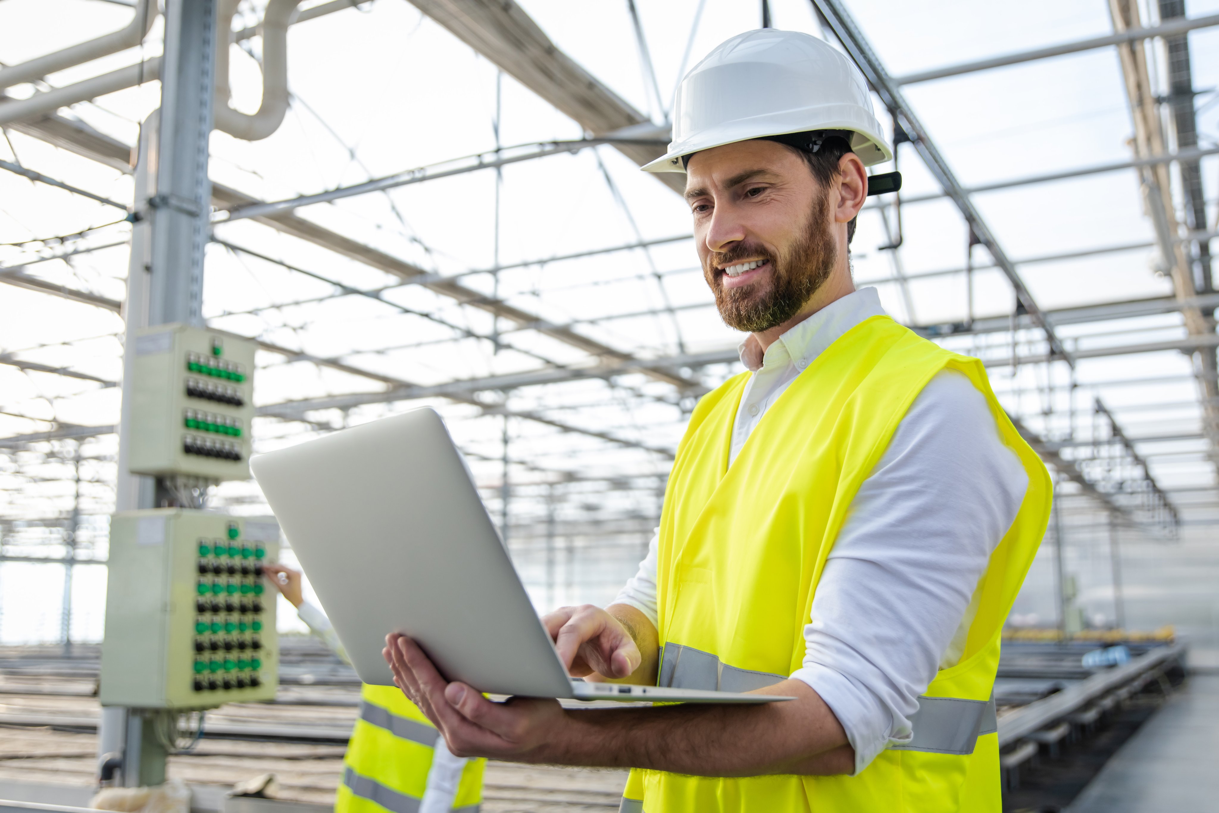 Male engineer at work. Young male engineer with a laptop checking the parameters at the construction site