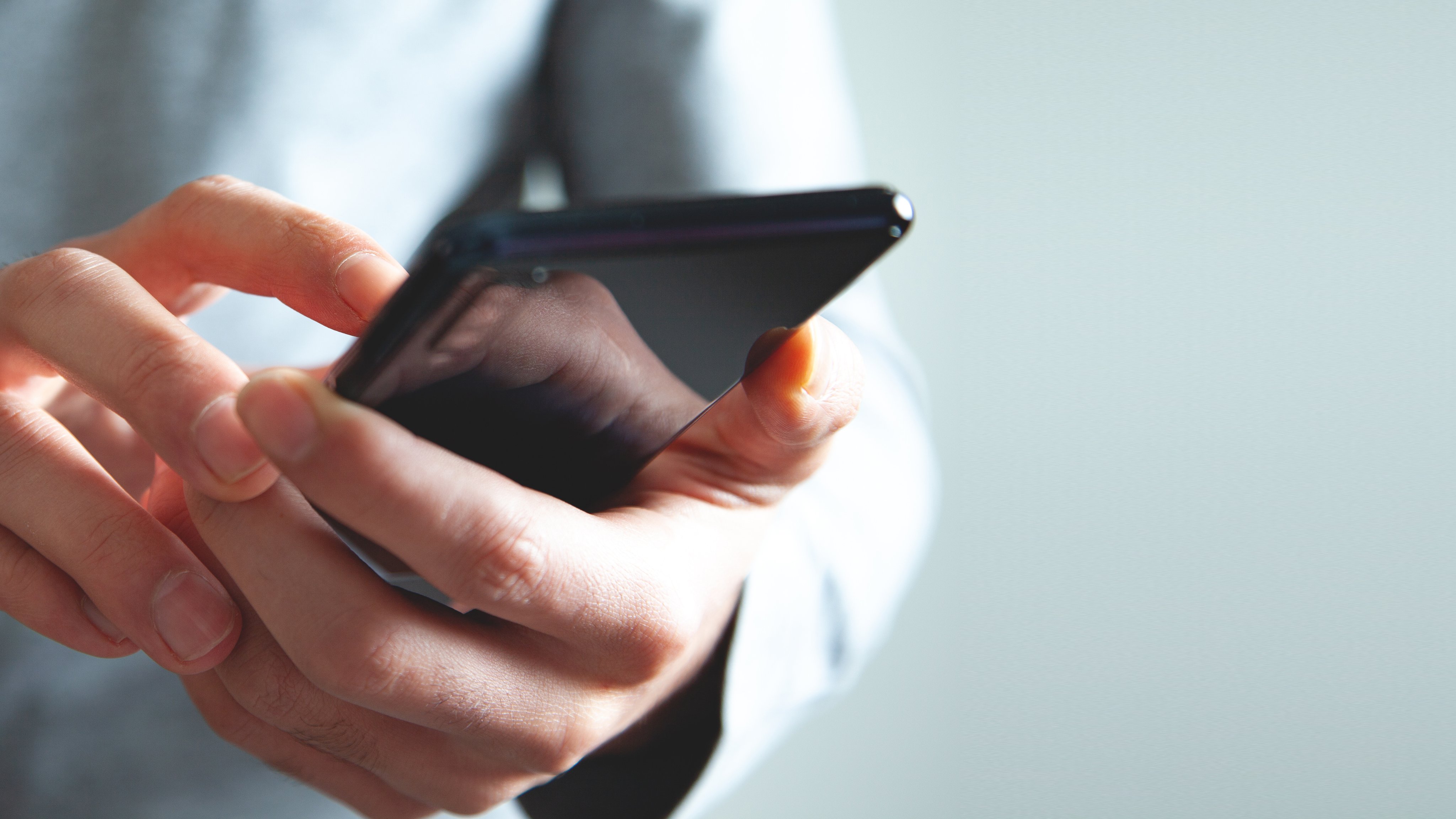 businessman using smartphone on isolated gray background