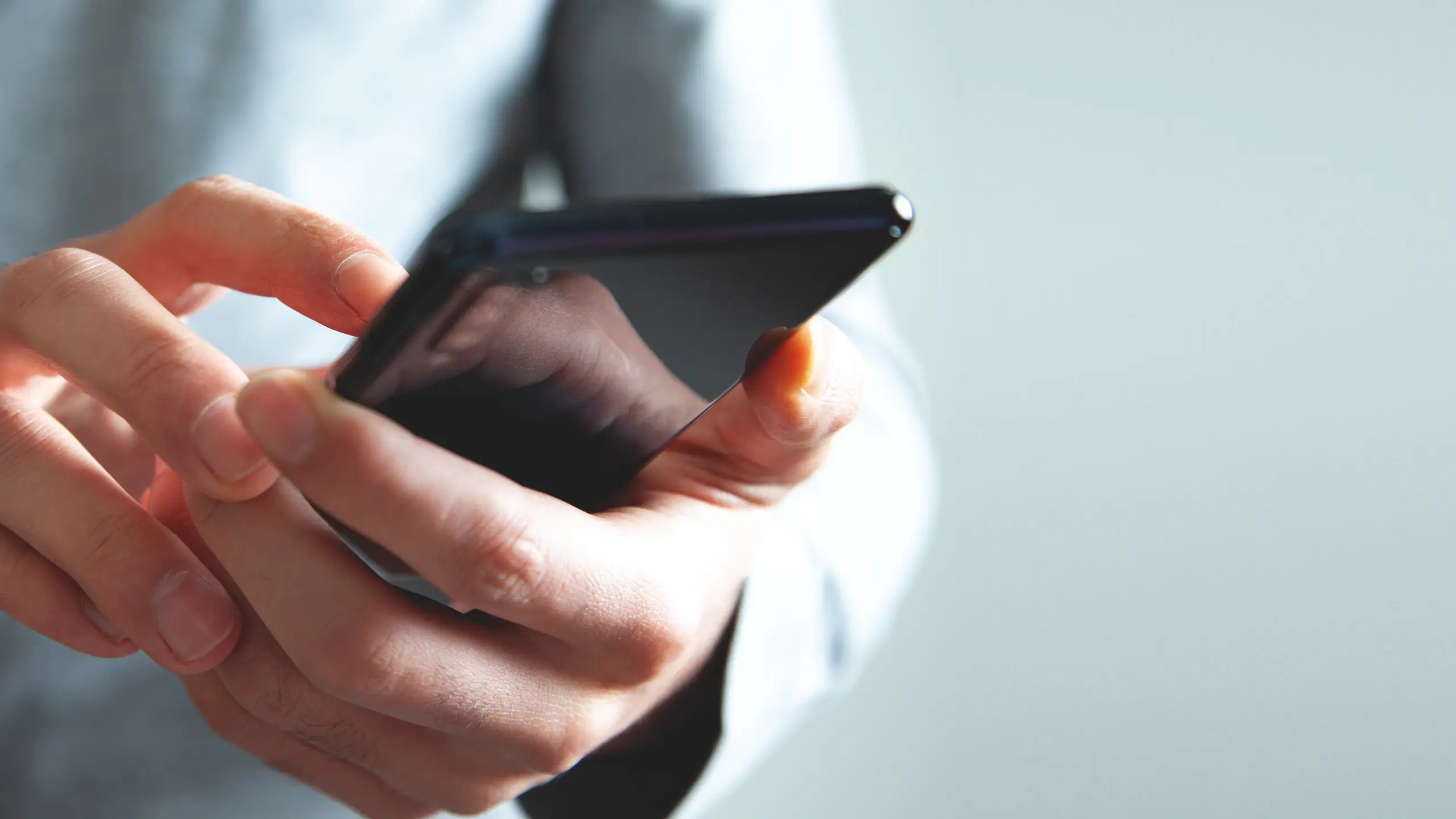 businessman using smartphone on isolated gray background