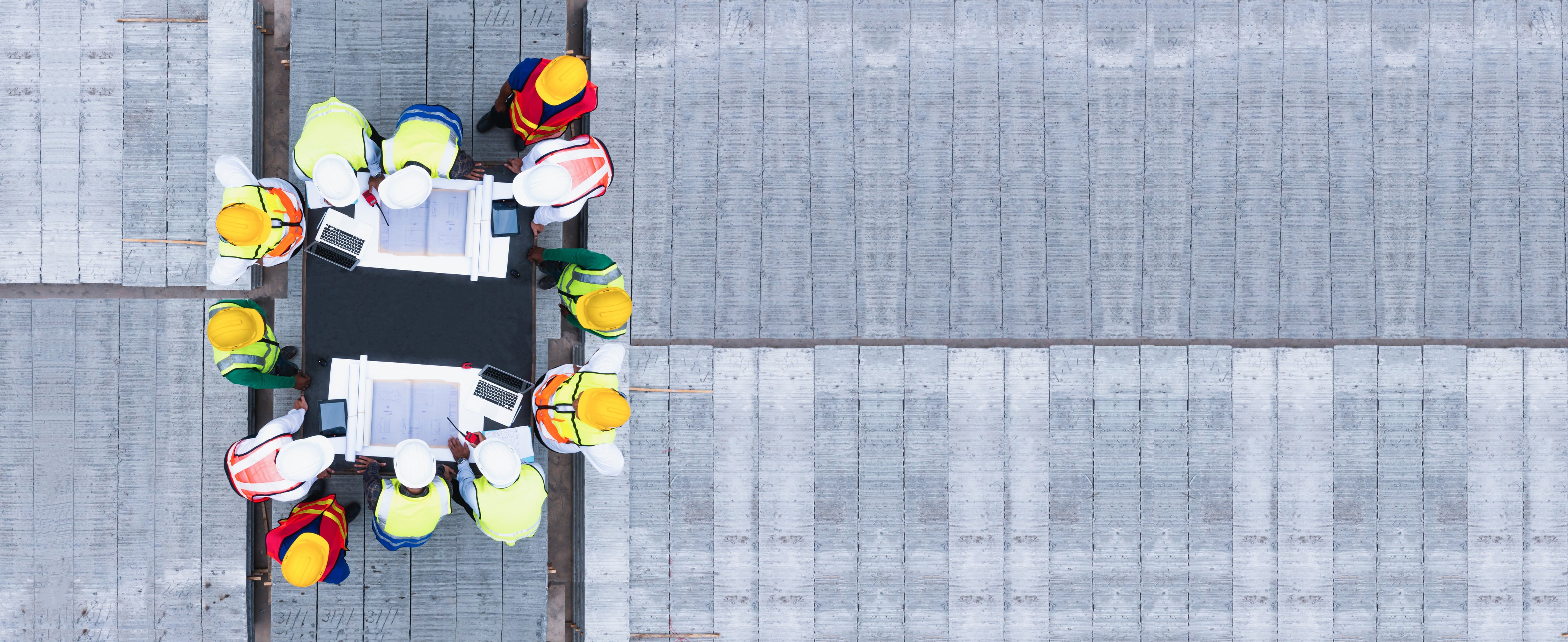 Top view of architectural engineering discussion at the table and his blueprints on Precast concrete, Cement slab floor concrete slab stacked construction site.meeting, discussing, designing, planning