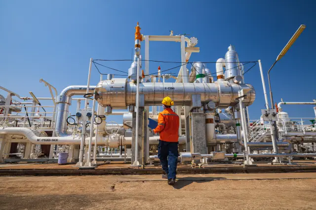 Male worker inspection at the exchanger of tank oil refinery pipeline plant steam vessel and column tank oil of Petrochemistry industry.