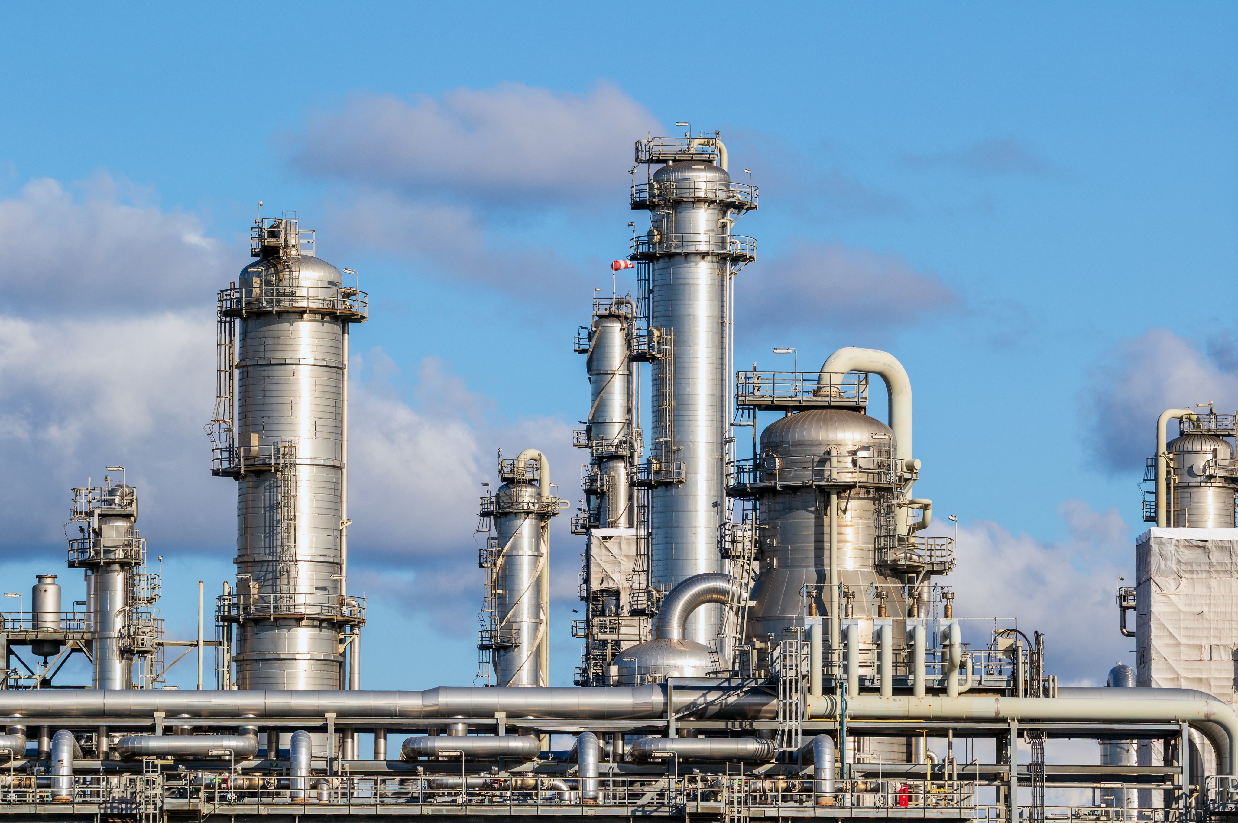 Detailed view of pipes, pipelines, and cooling towers at an oil refinery power station showcasing advanced industrial infrastructure and energy production.