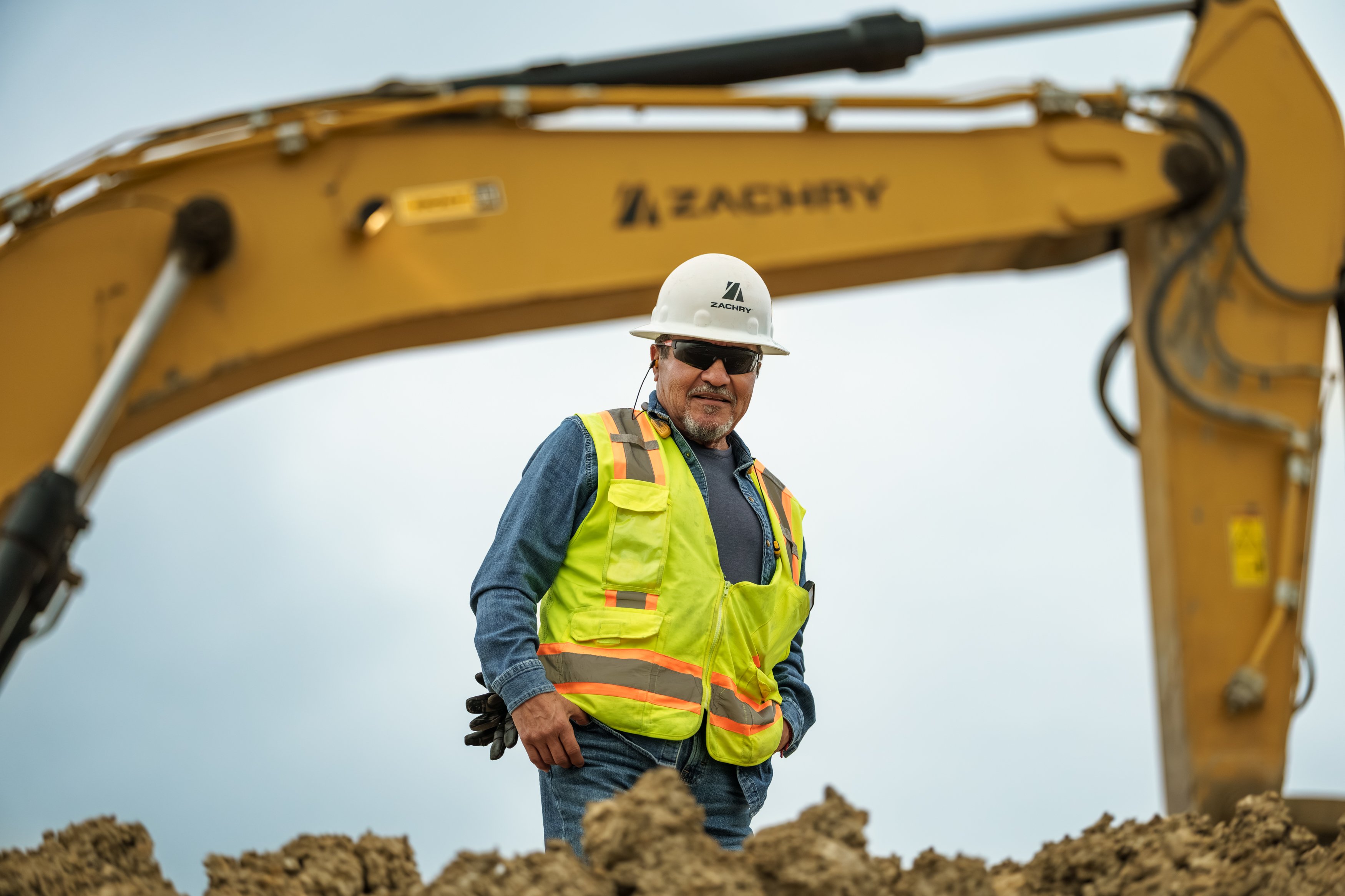 Zachry construction worker at a jobsite with an excavator